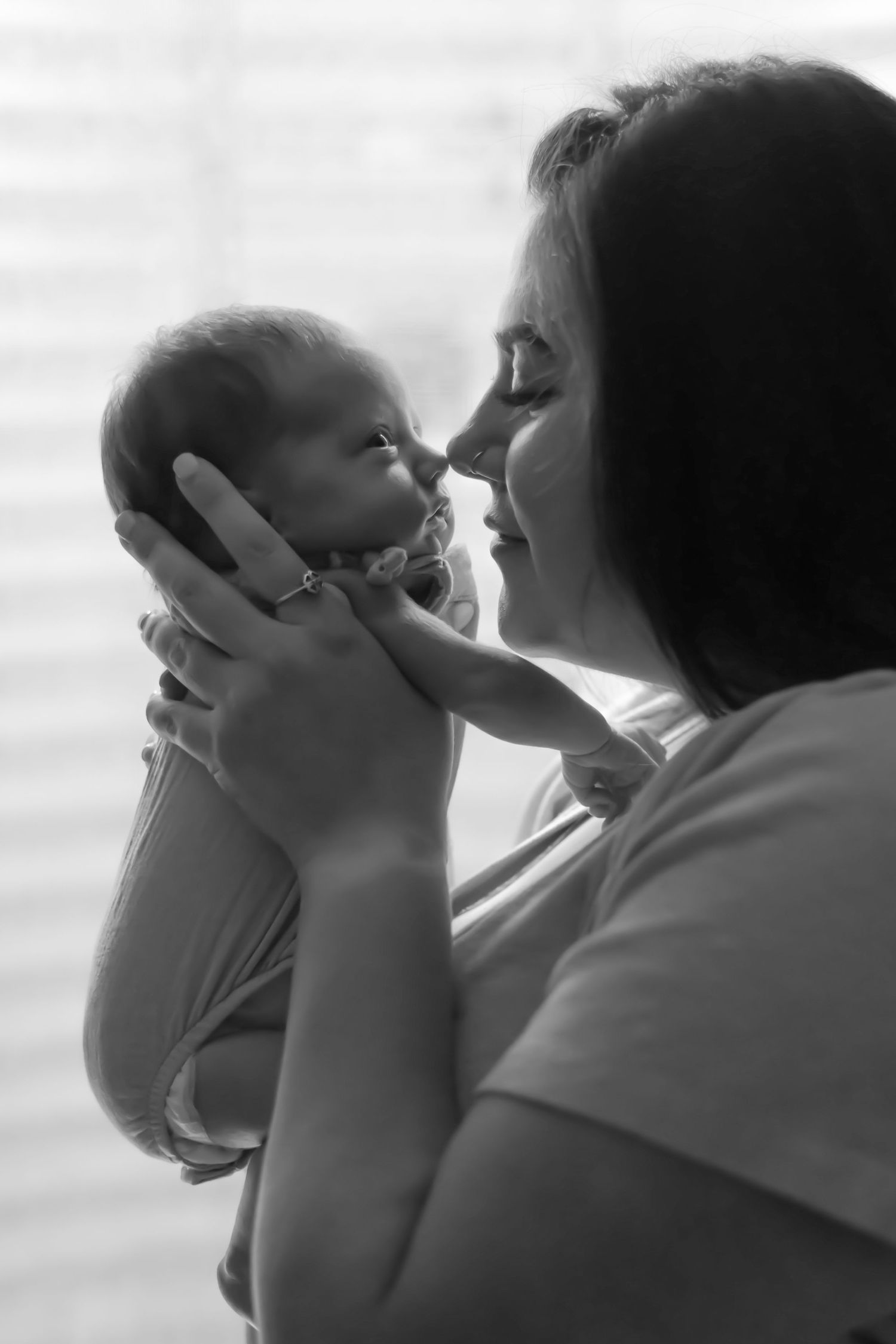 Tender black and white portrait of mother and newborn sharing an intimate moment.
