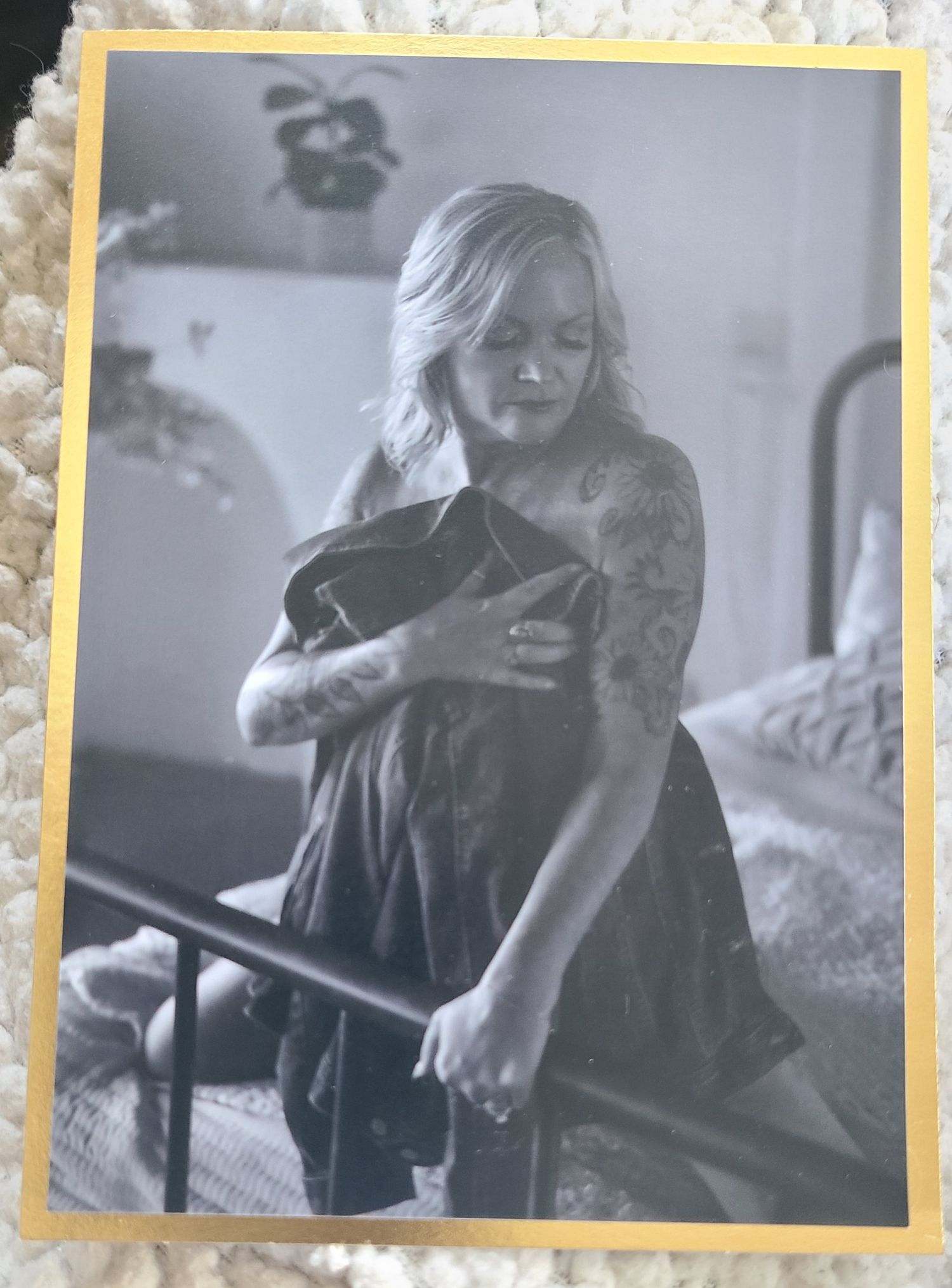Black and white framed photo showing figure in dark dress holding fabric.