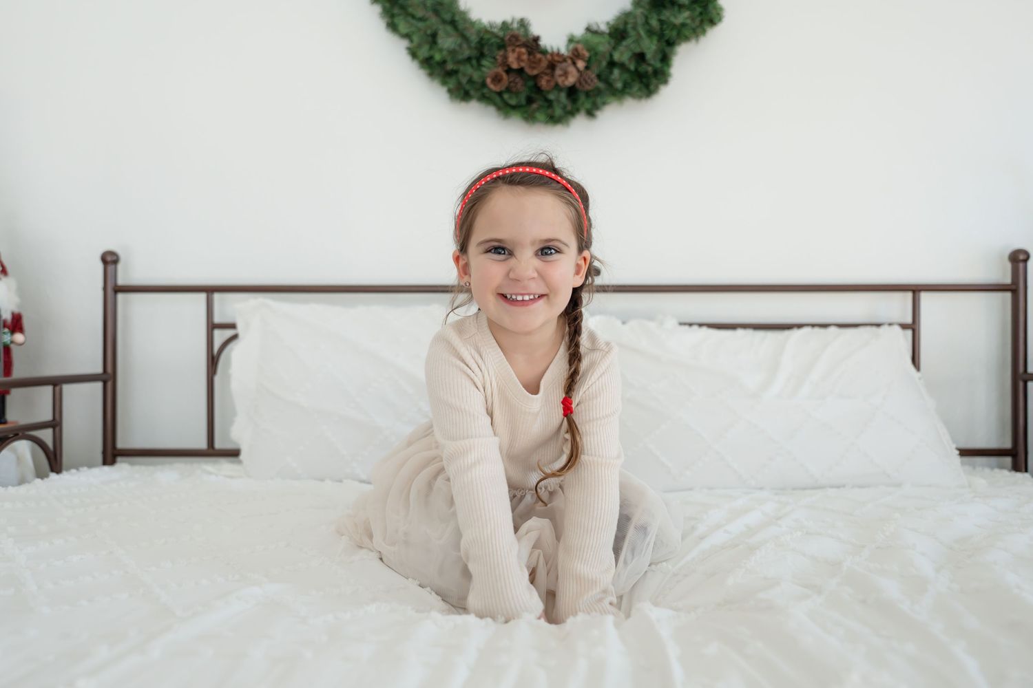 A festive holiday scene with a wreath and cozy winter decor in a bright white room.