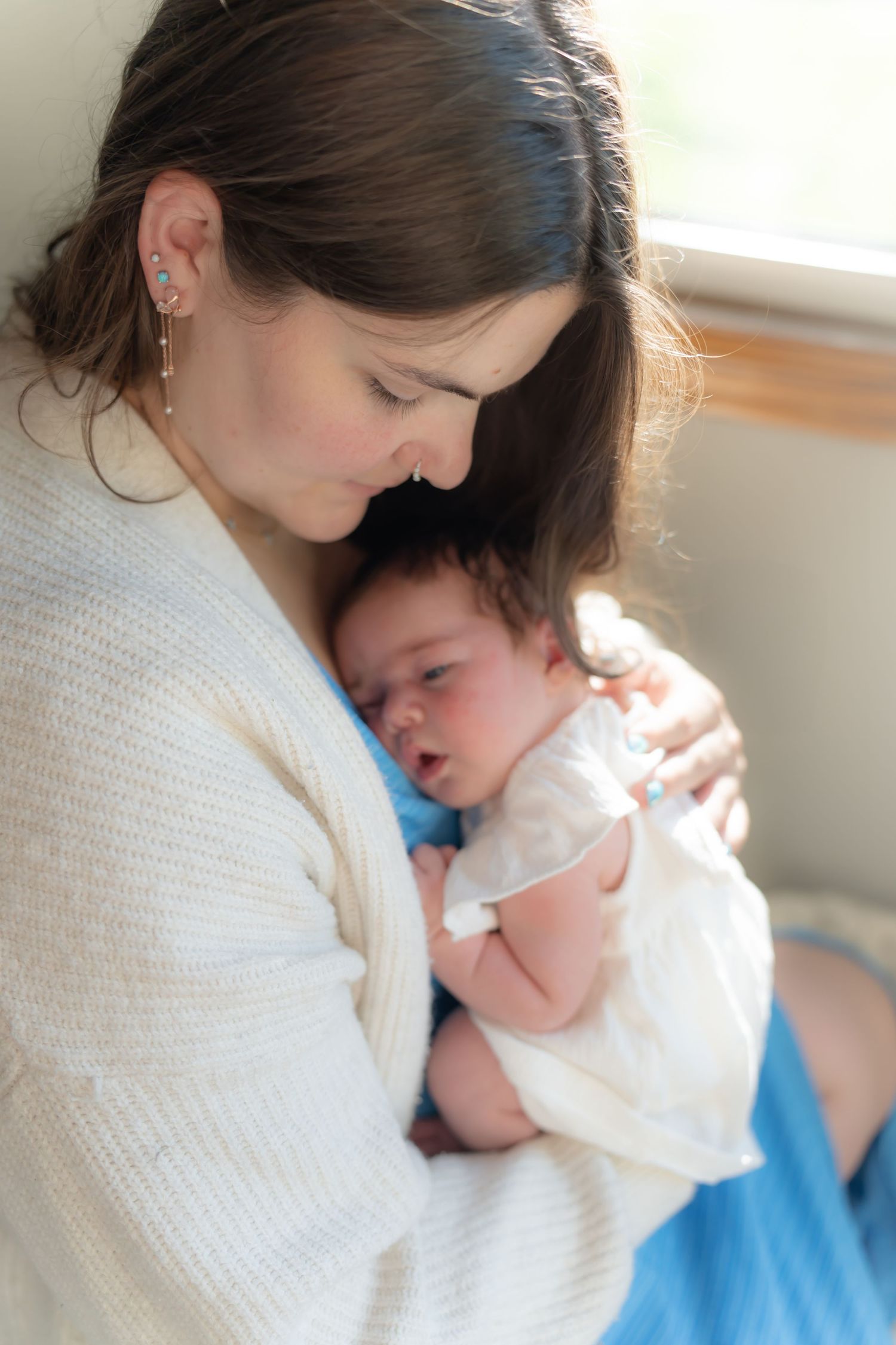 Intimate portrait of parent and newborn baby sharing a quiet moment.