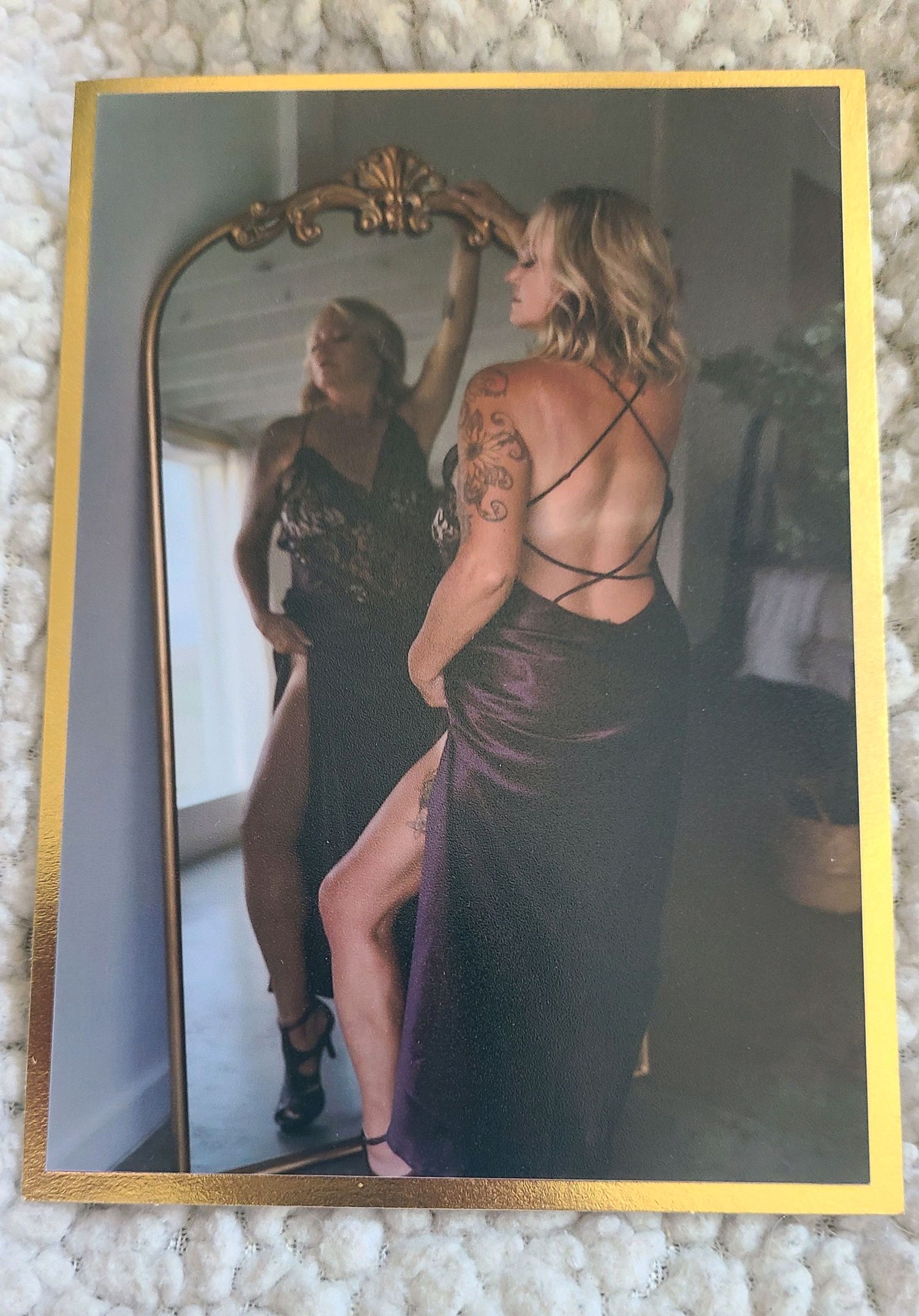 Framed photo showing reflection in gold-trimmed mirror with purple dress.