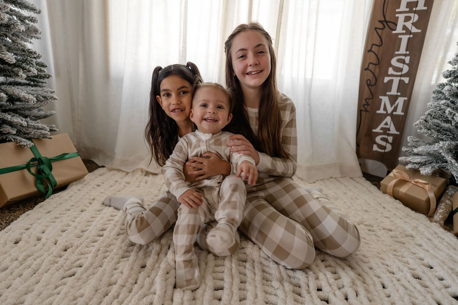 A series of photos showing a cozy family moment on a bed with a Christmas tree visible in the background.