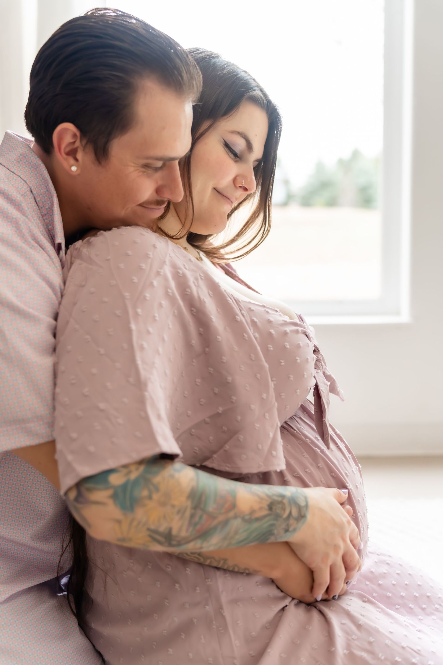 Loving embrace captured in soft lighting with pink polka dot fabric details.