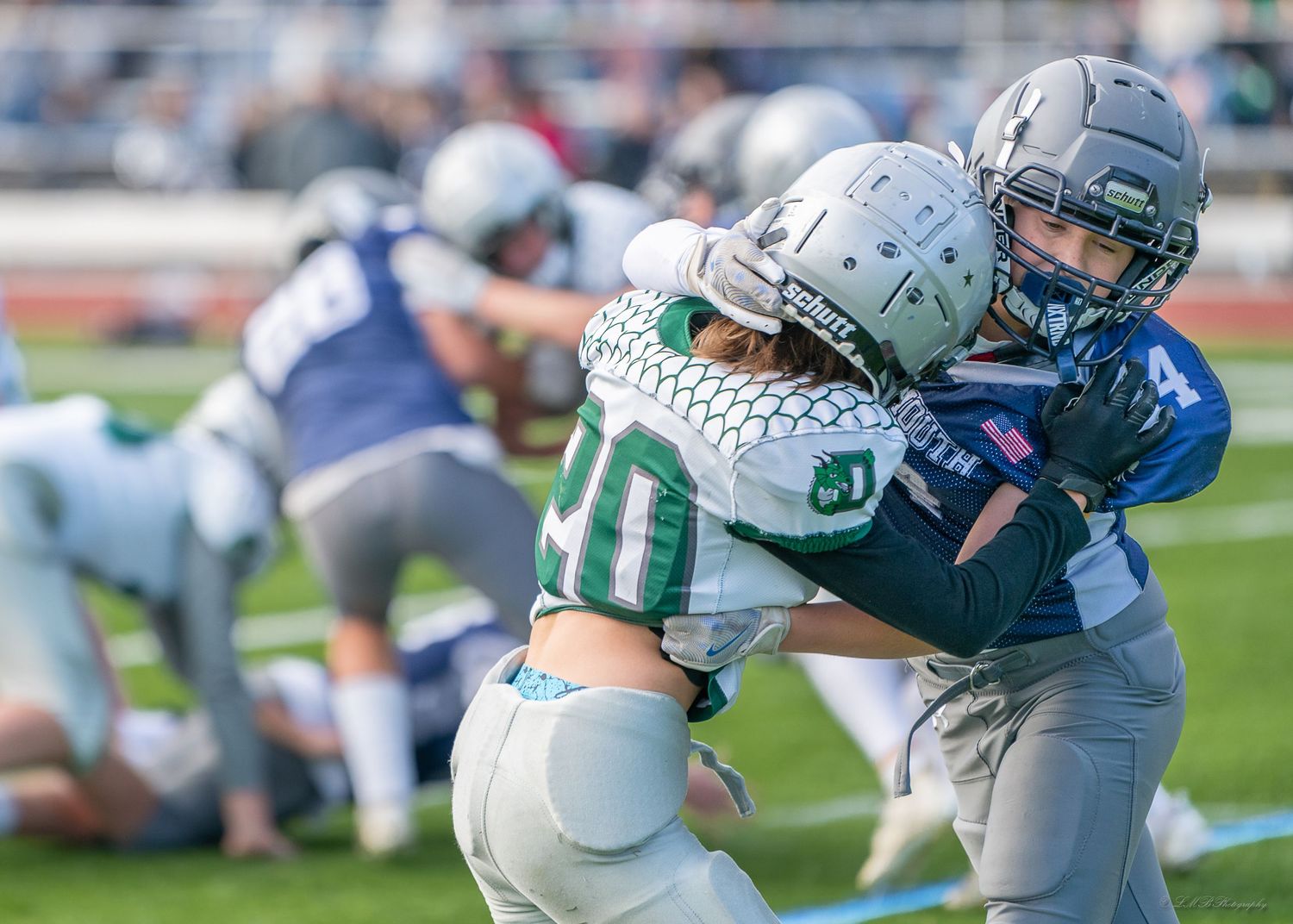 Close-up action shot of football players colliding during a tackle play.