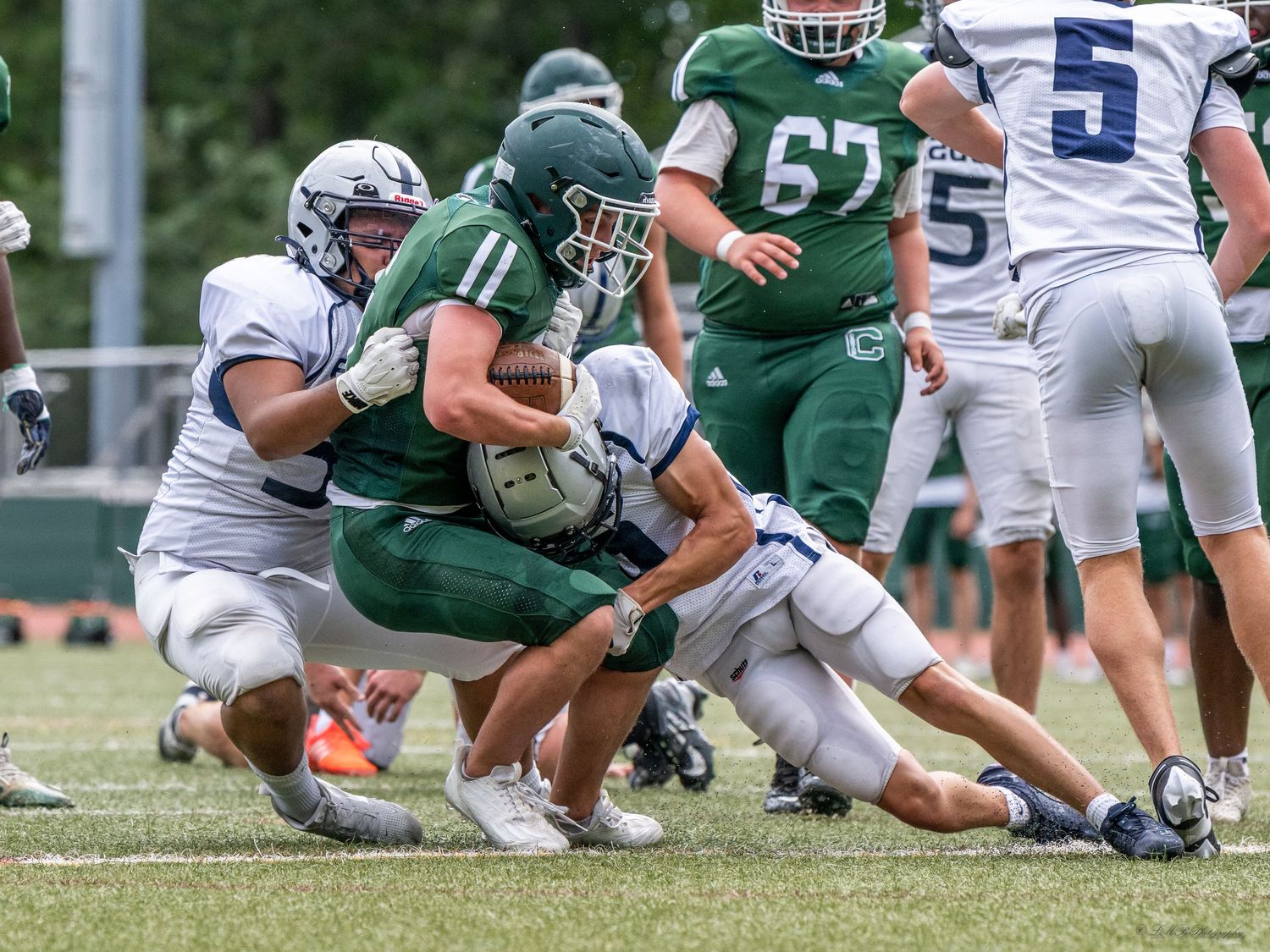 Football players collide in a tackle during an intense game on the field.