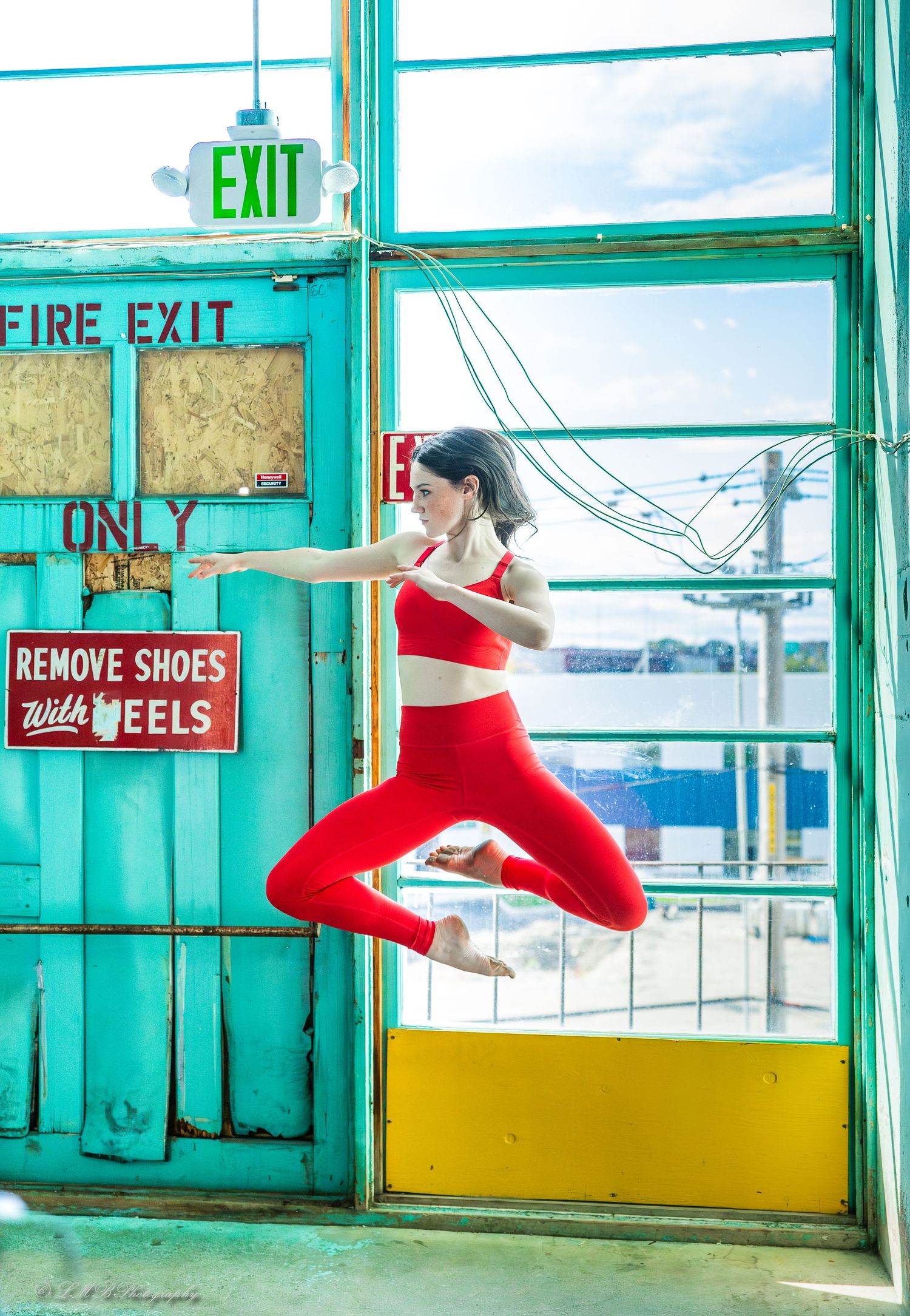 Red-clad legs performing dynamic movements across a turquoise-colored roller skating rink.