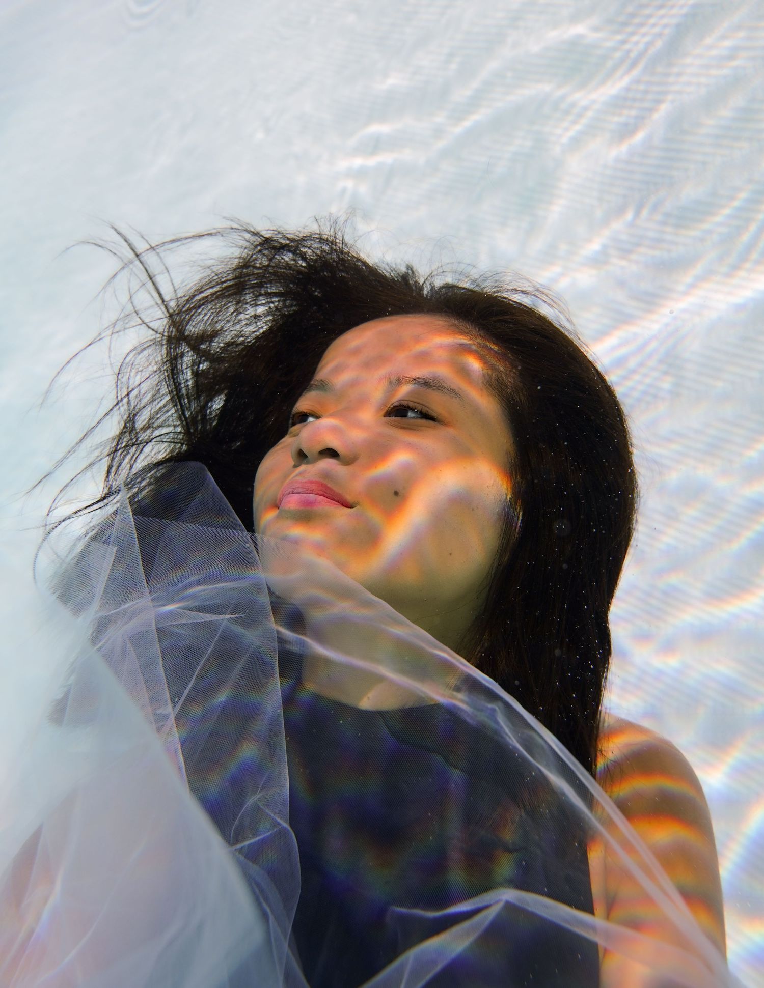 Abstract underwater photography with light refractions creating prismatic patterns.