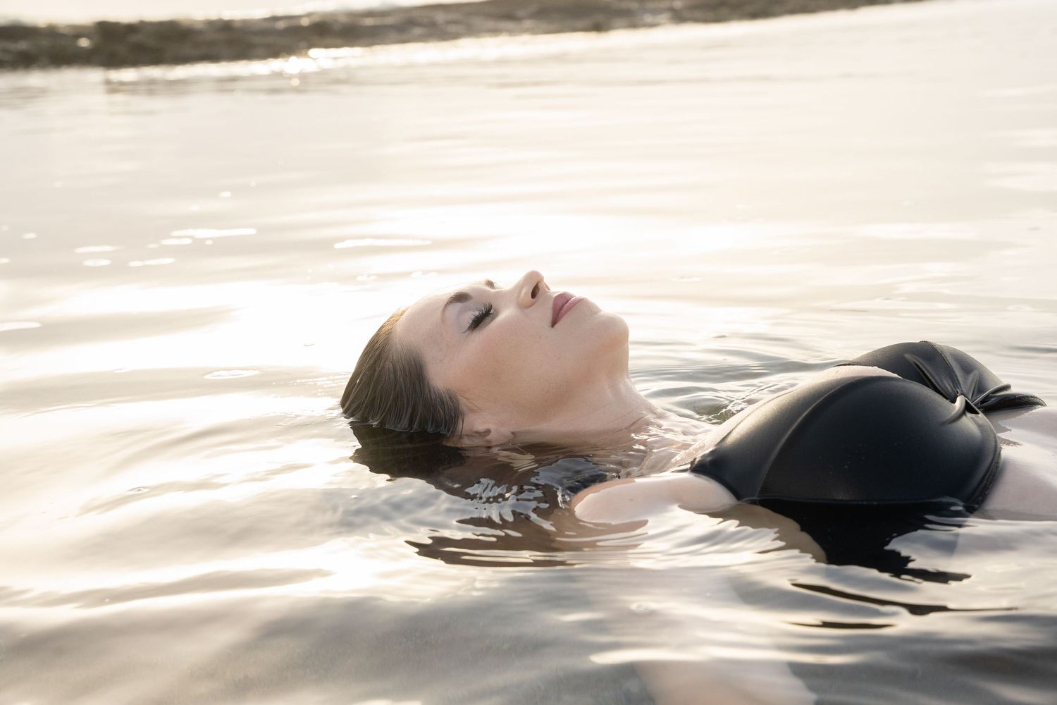Series of serene black and white photos showing a person floating peacefully in calm waters.