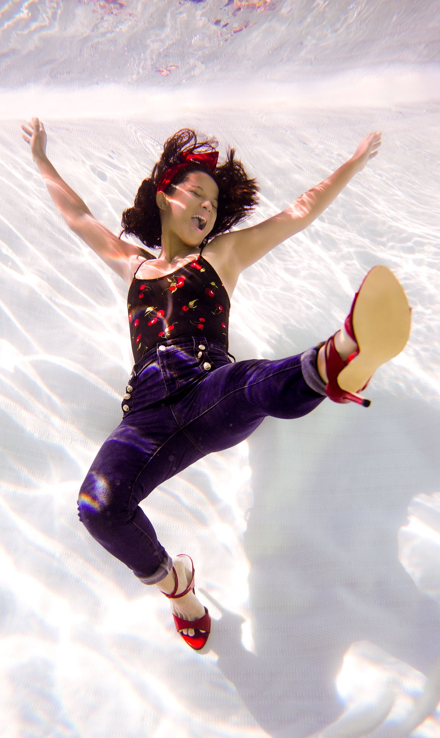A figure in purple performs a graceful underwater dance sequence captured in multiple frames.