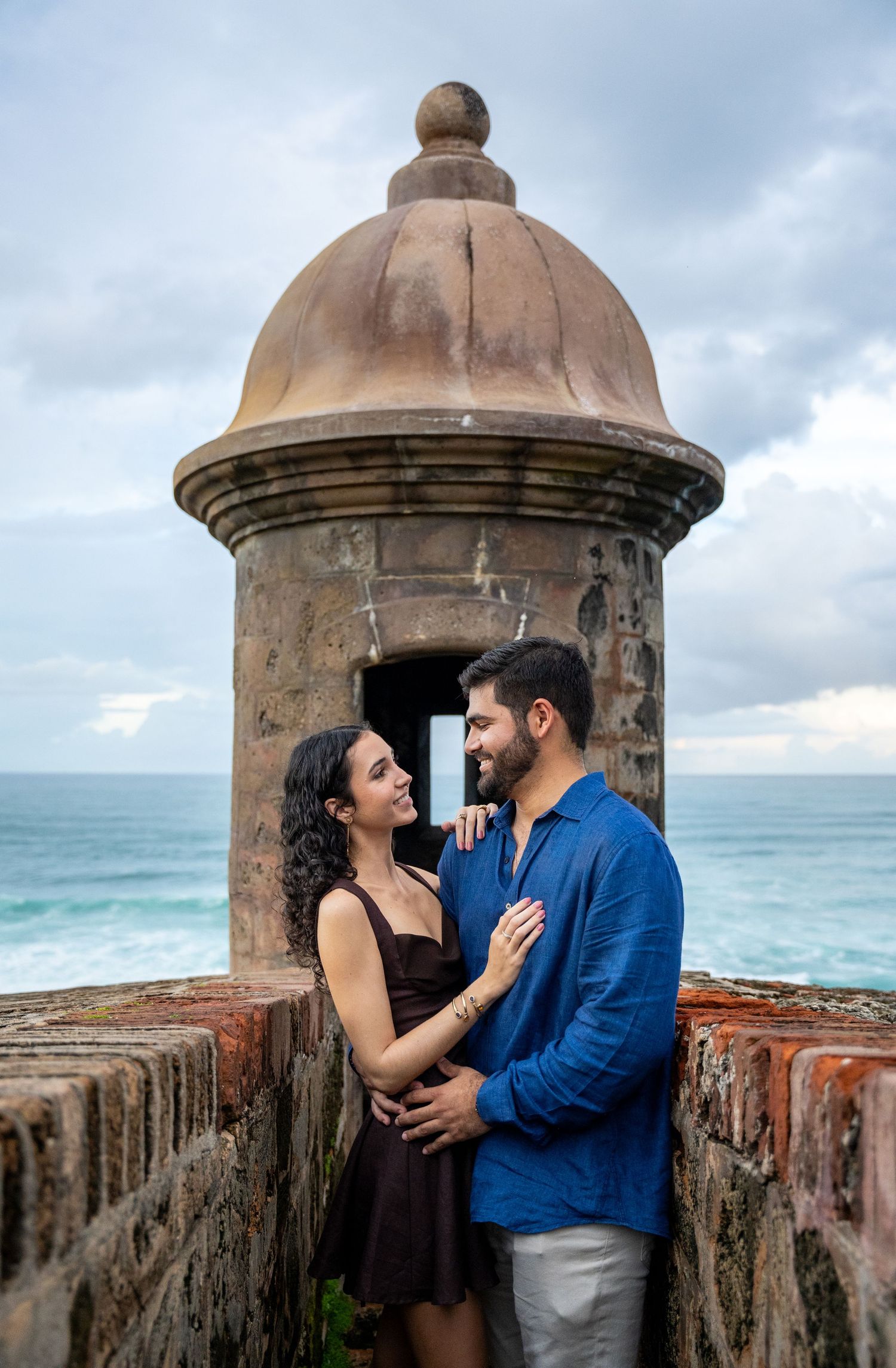A romantic photoshoot at a historic stone fortress overlooking the ocean.