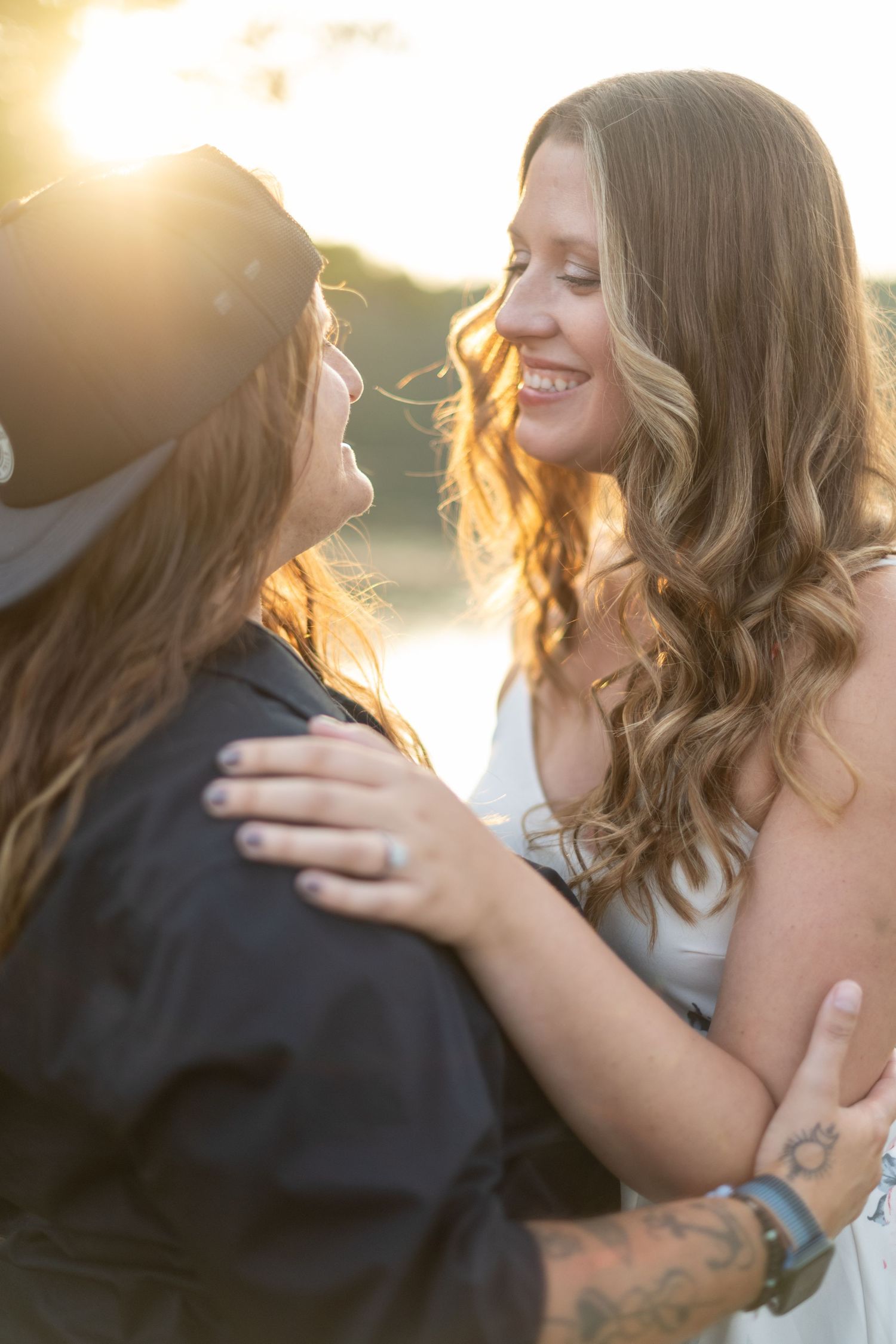 A romantic sunset moment between two people with golden backlight creating a warm glow.