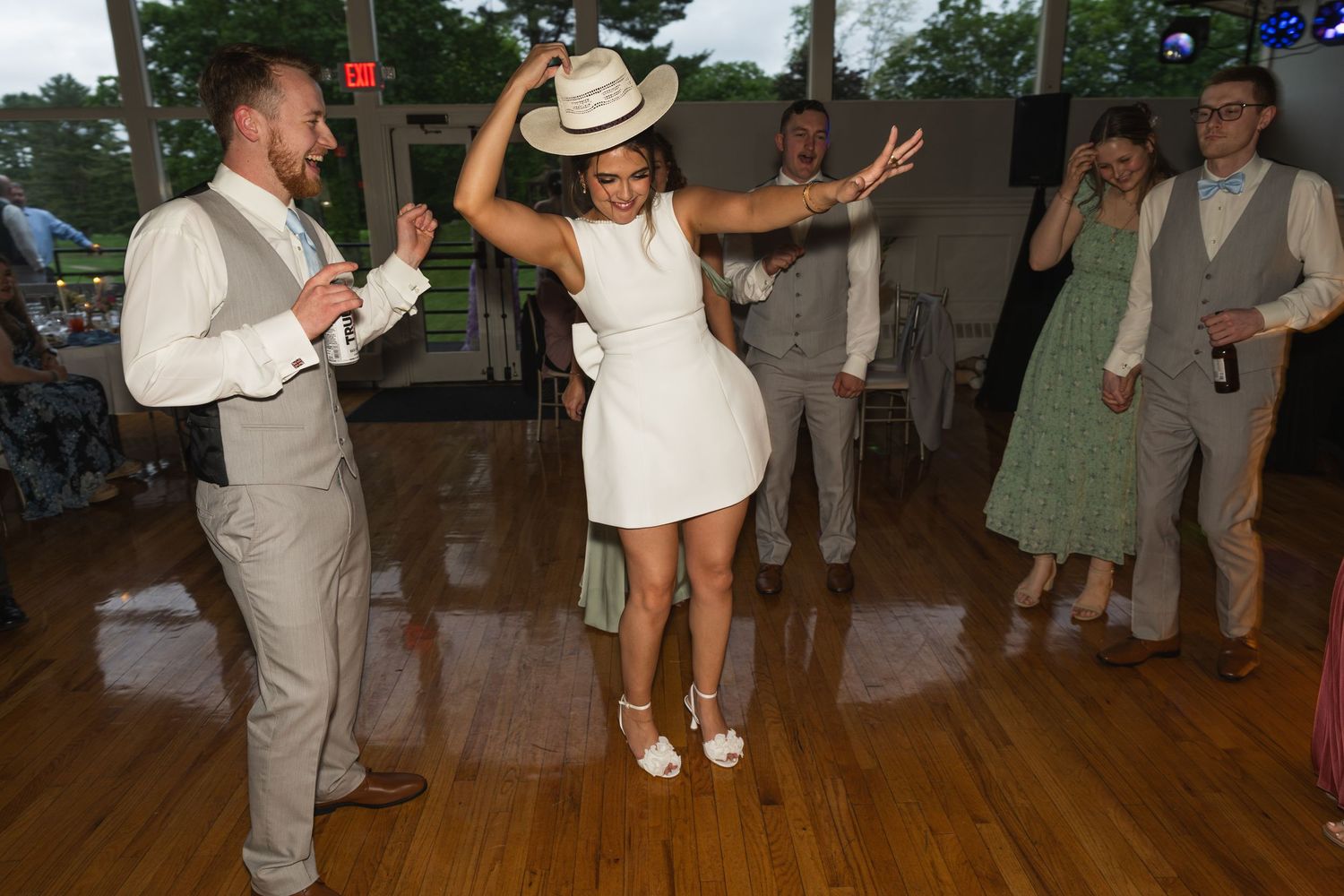Wedding reception dancing celebration on rustic wooden dance floor.