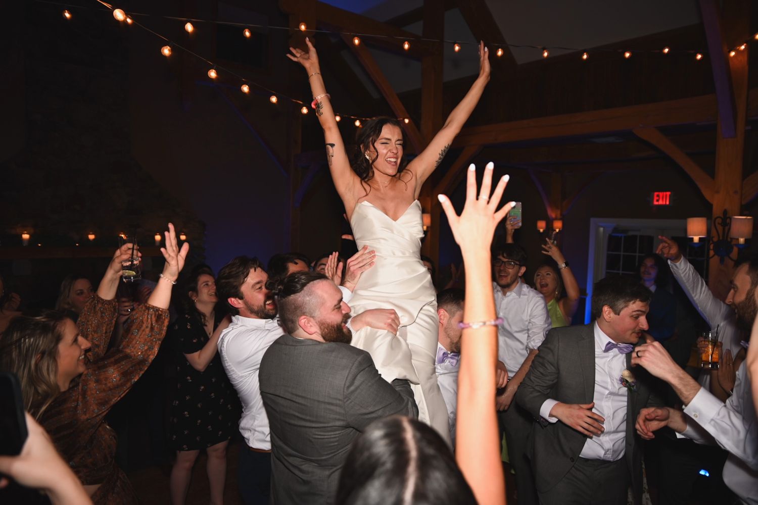 Dance party celebration with raised hands under twinkling lights.