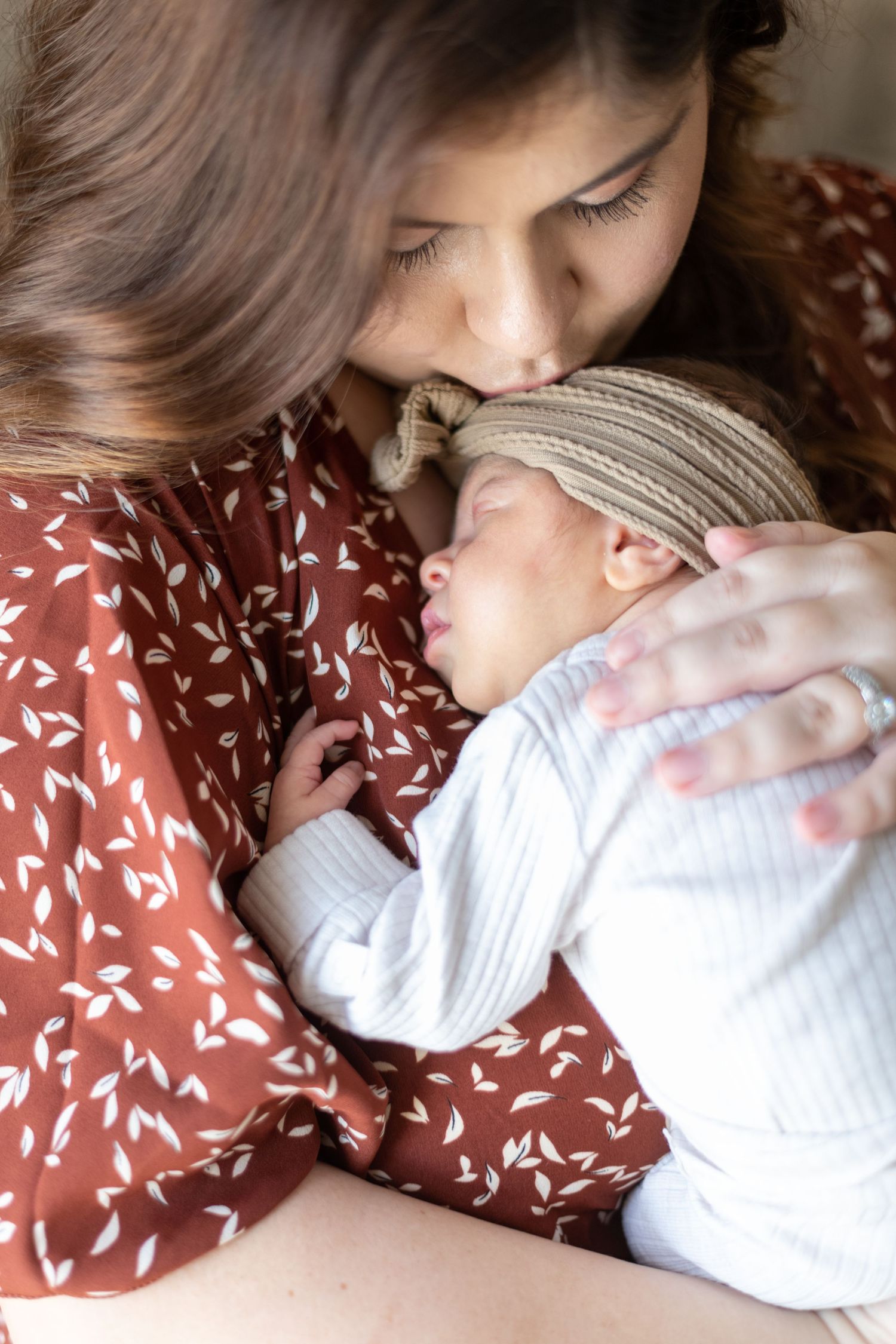 Tender moment between parent and baby in soft lighting.