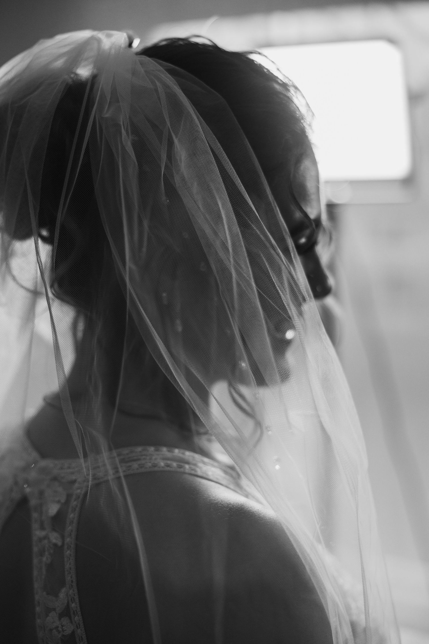 Delicate lace and tulle veil details captured in soft black and white.