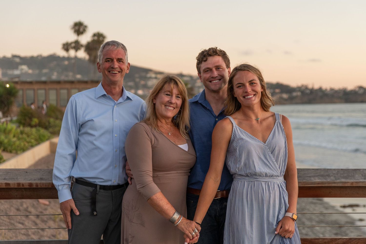 Group enjoying a relaxed moment together on the beach at sunset.
