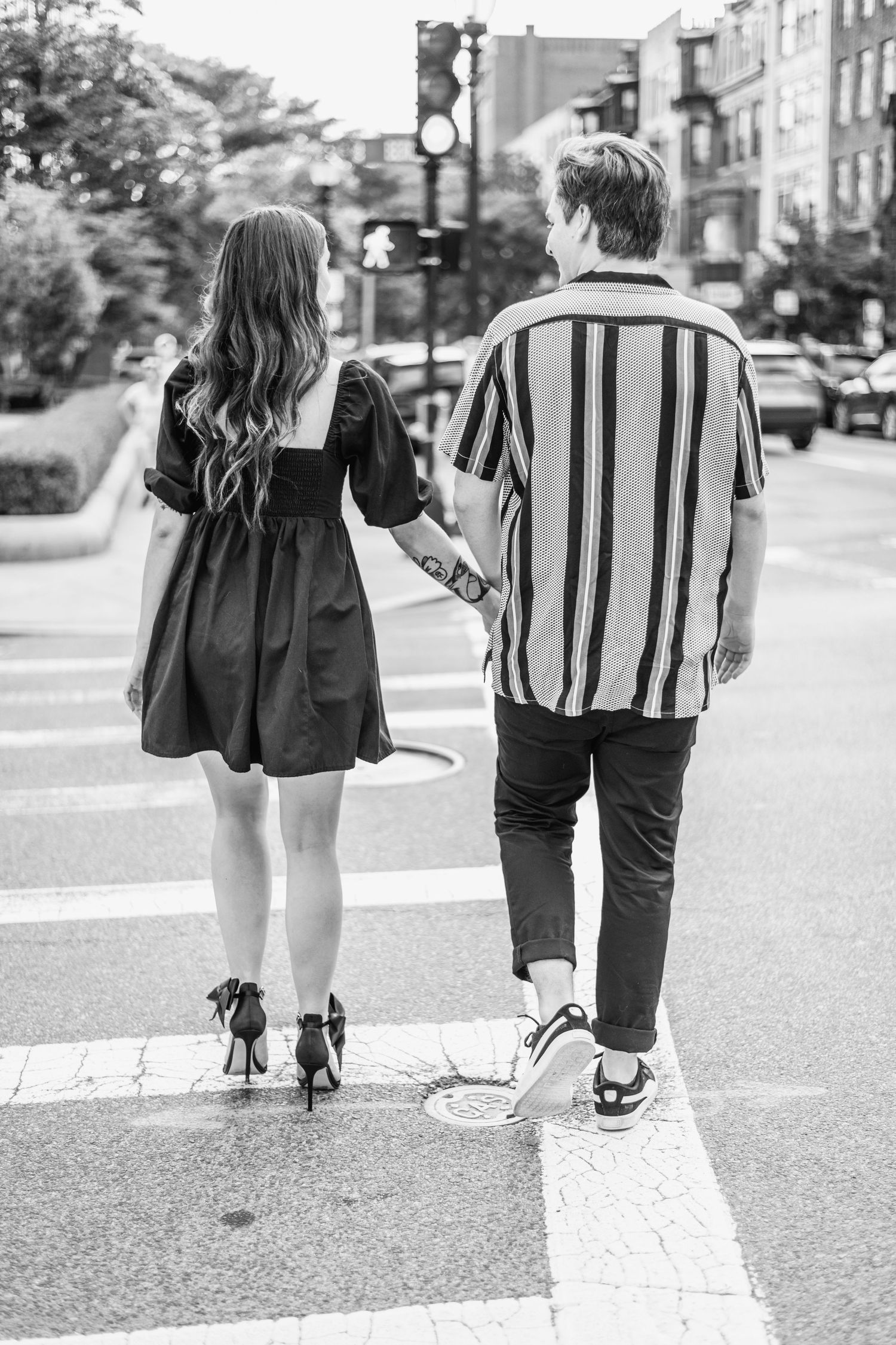 Black and white series of a couple walking together on a city street from behind.