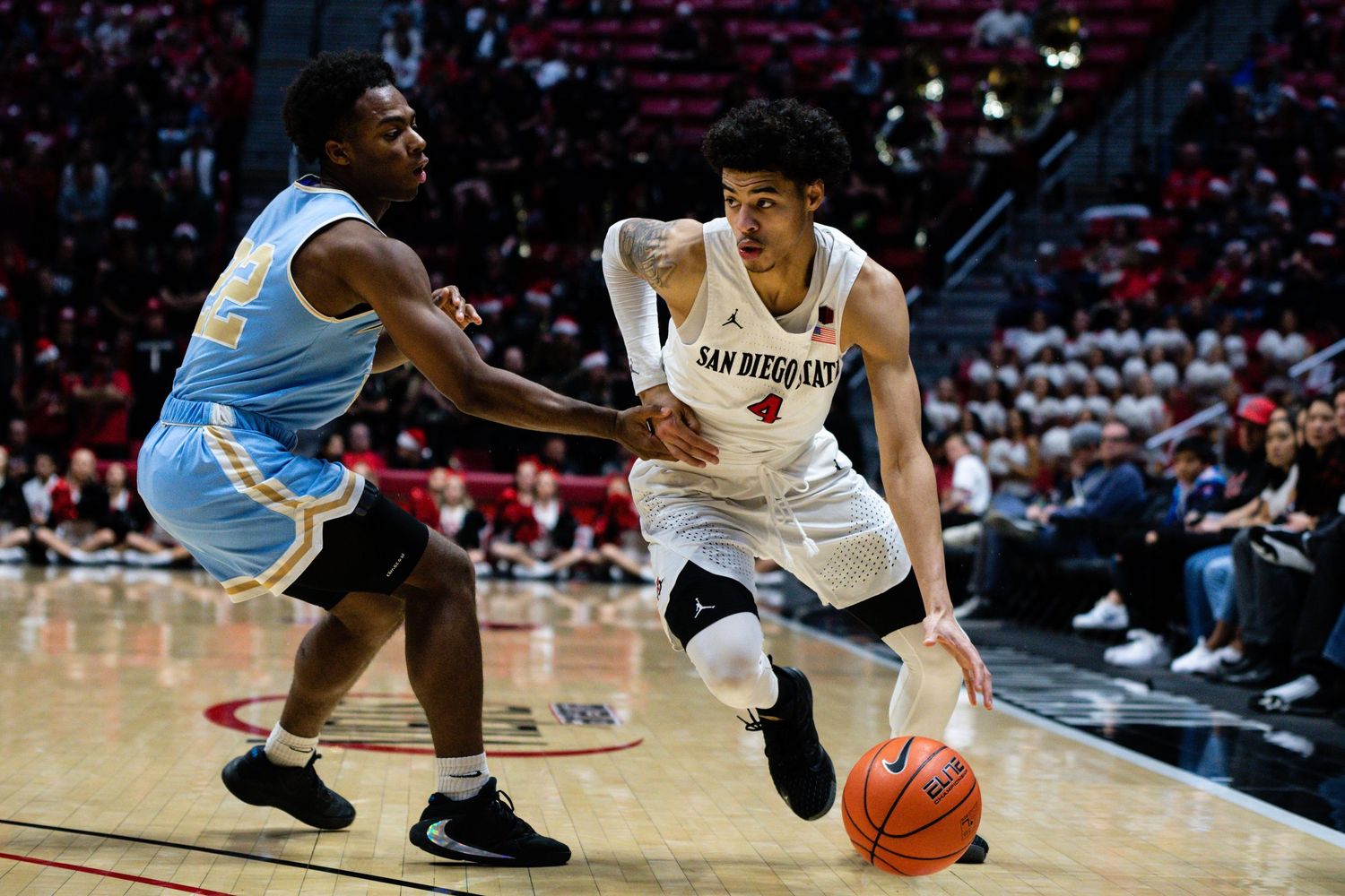 San Diego State basketball player drives to the basket against a Southern University defender during a college basketball game.