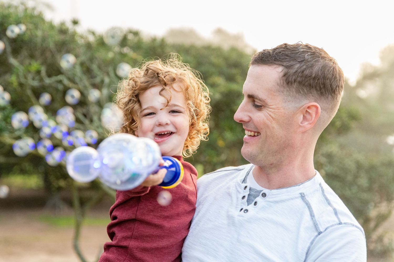 Candid family moments captured during golden hour in a natural outdoor setting.