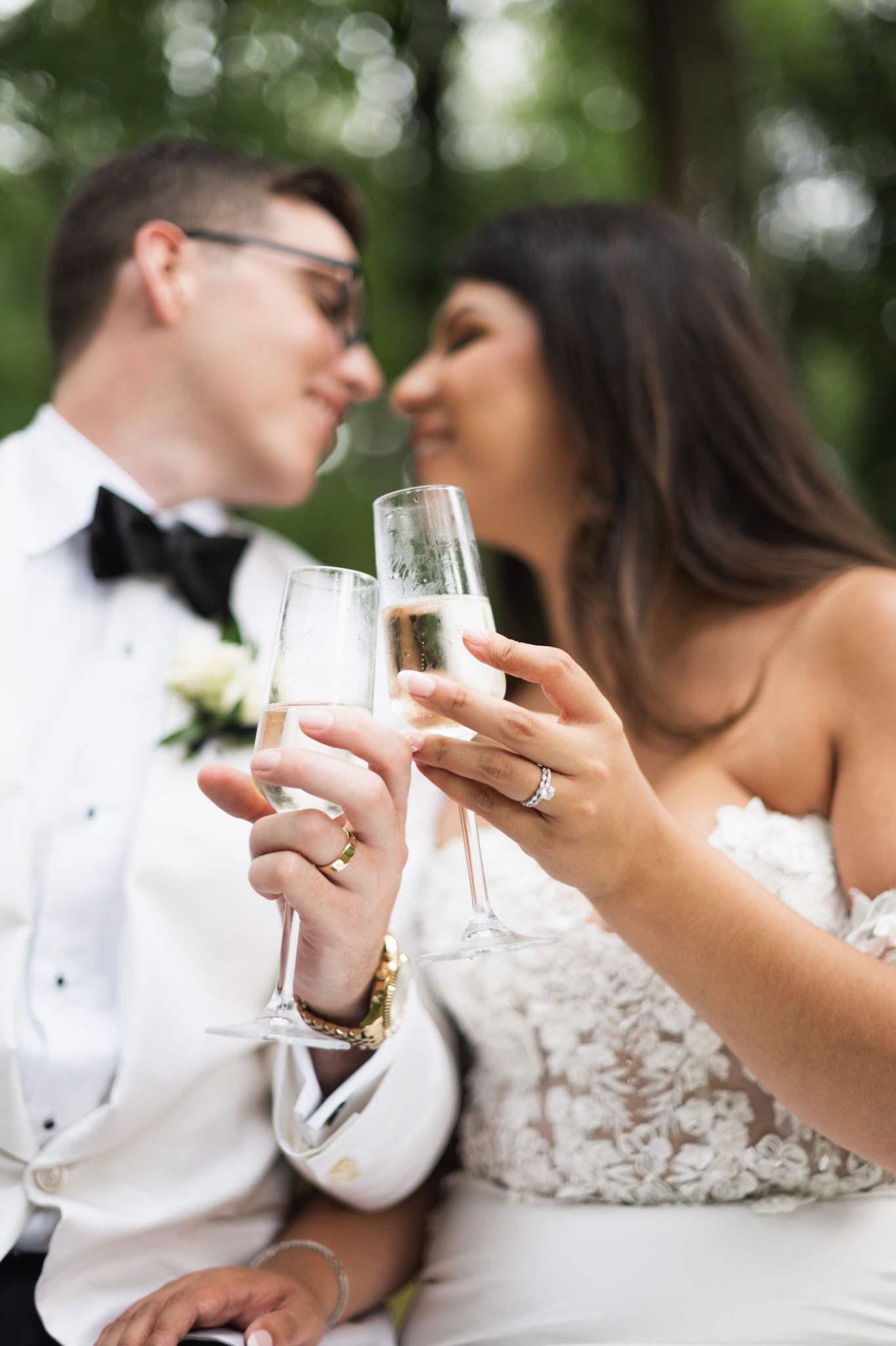 An intimate moment captured as a couple toasts with champagne flutes at their wedding.