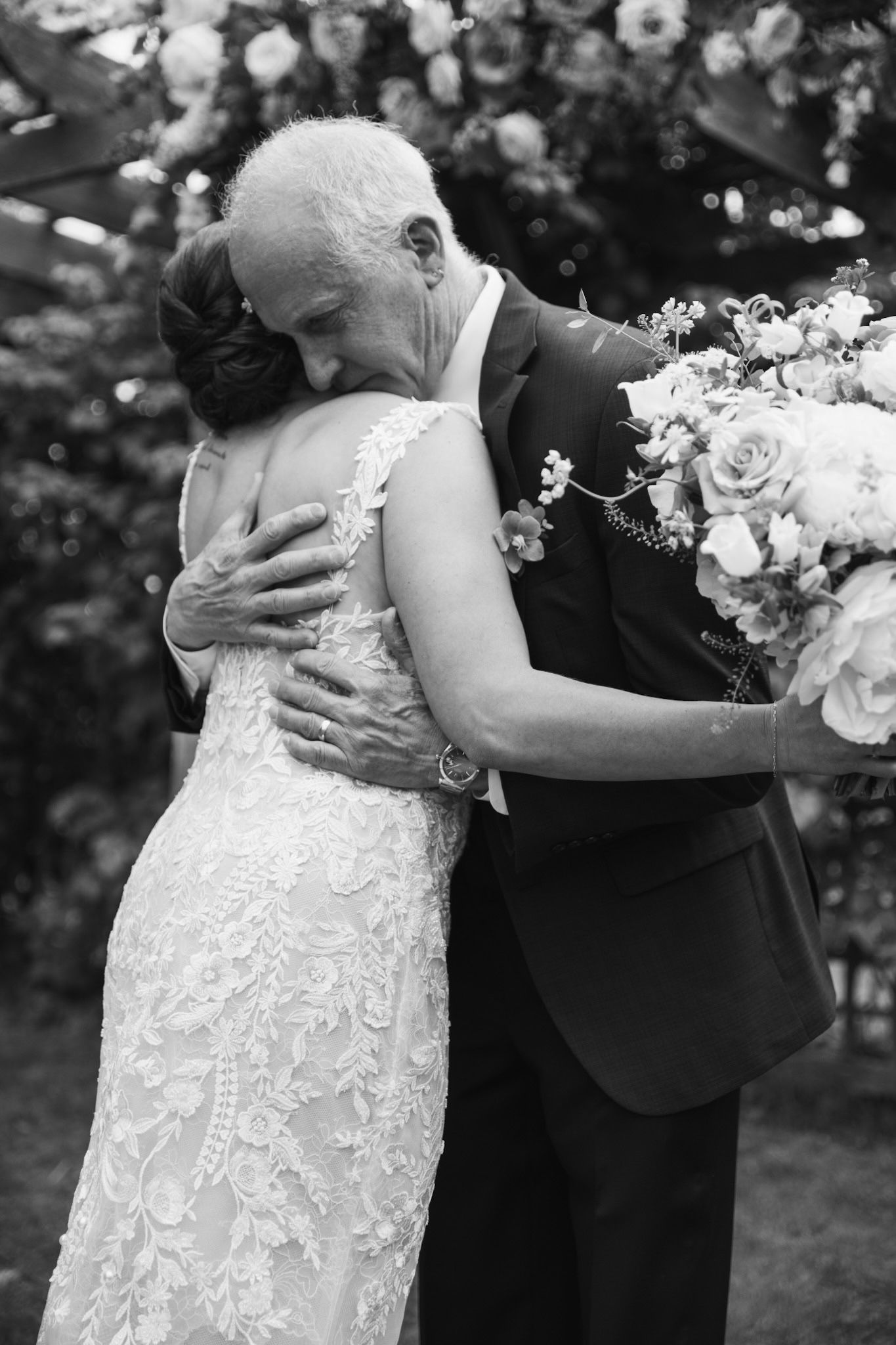 Black and white wedding photos capturing emotional moments in an outdoor garden setting.