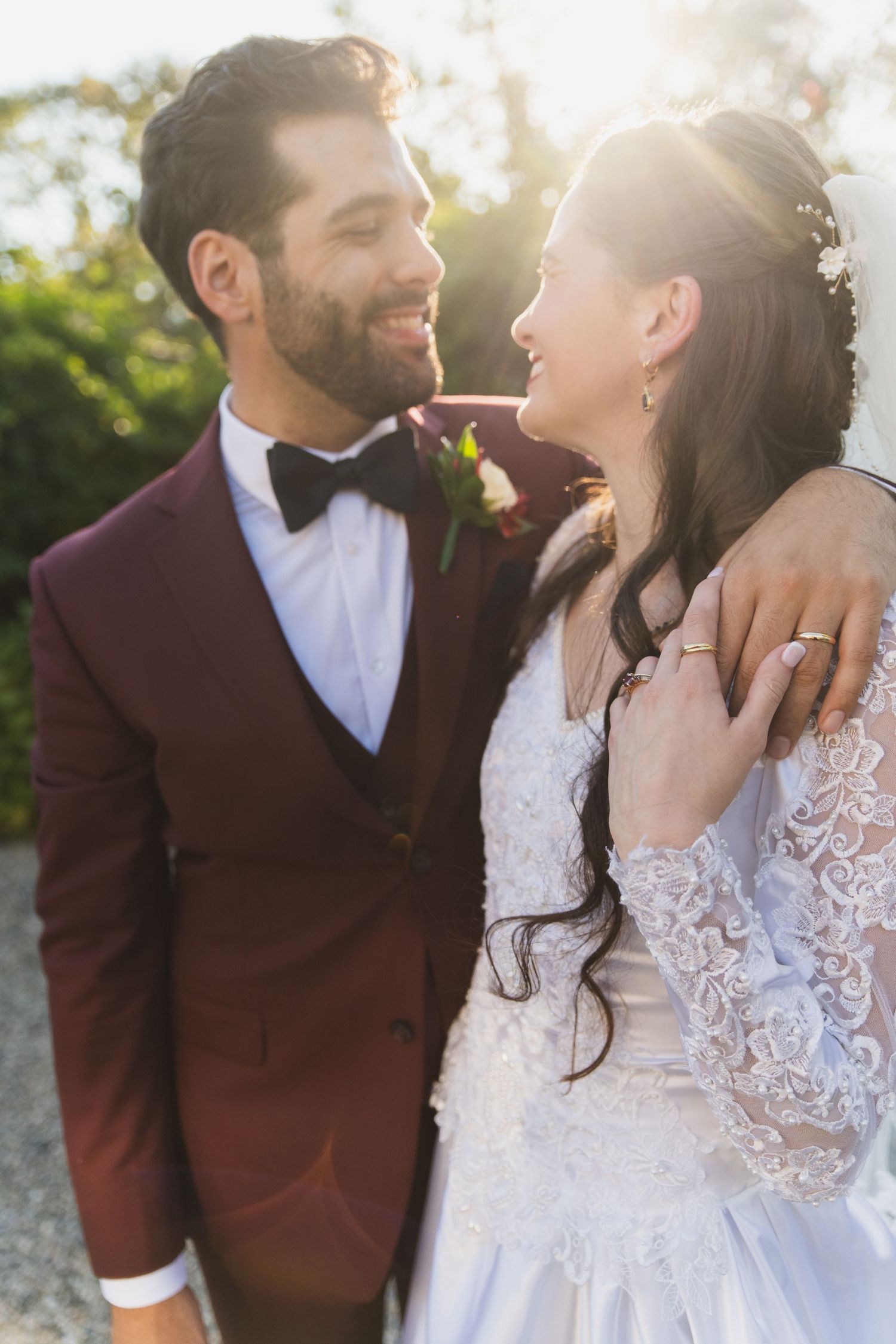 Romantic outdoor wedding portraits capture intimate moments in burgundy and white attire.