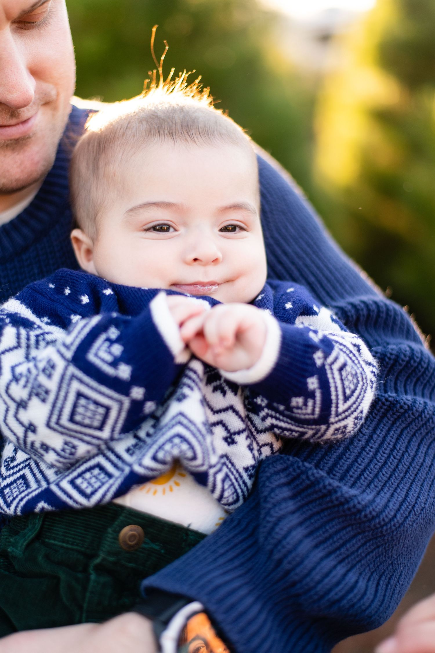 A sweet winter moment showing a navy patterned sweater and gentle smile.