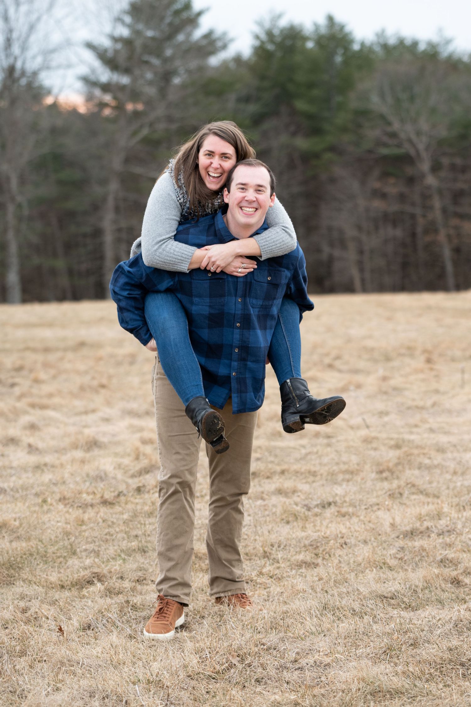 A playful sequence showing one person giving another a piggyback ride in a field.