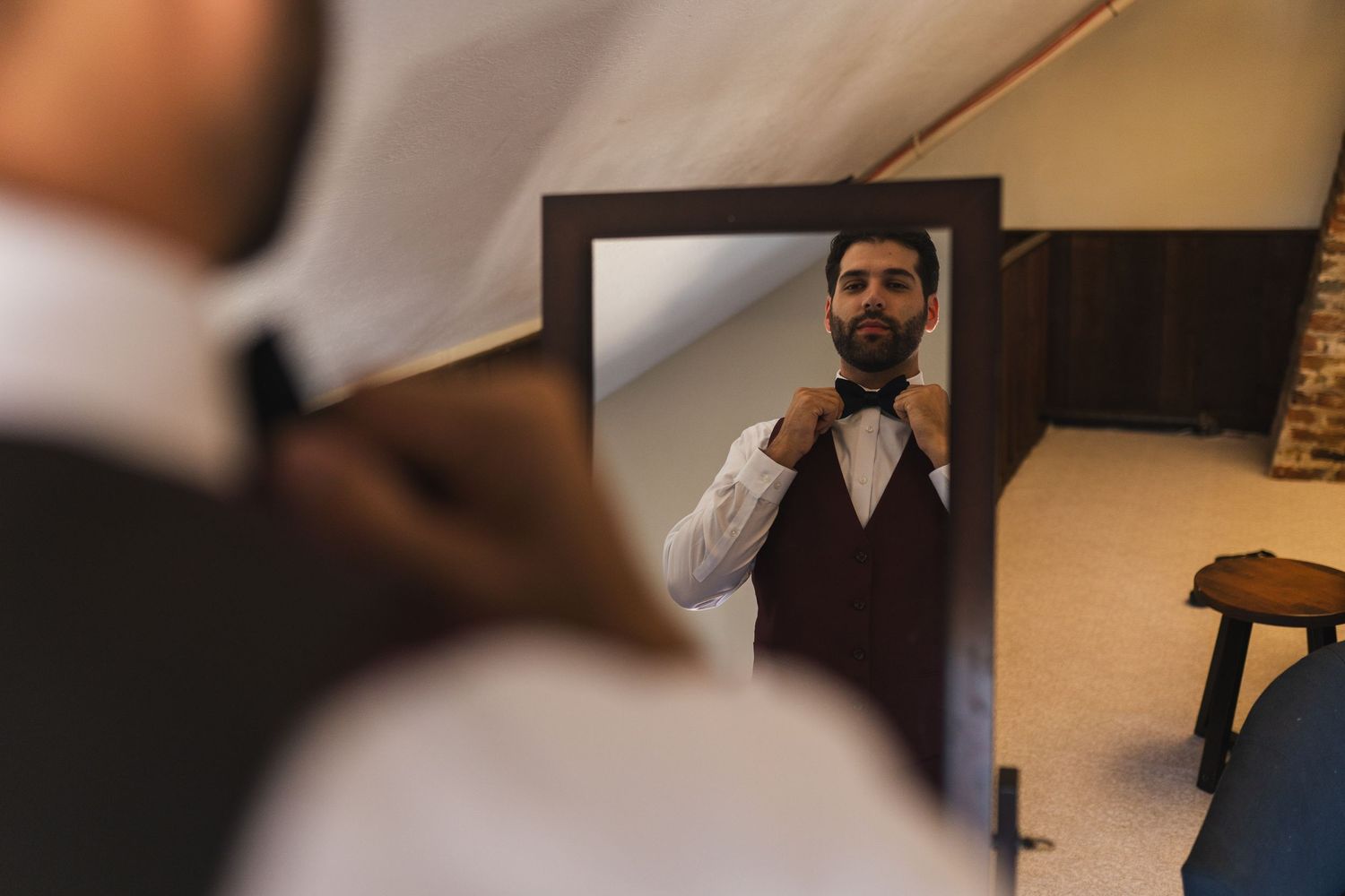 Professional wearing a vest and dress shirt poses in various angles against a warm-toned interior setting.