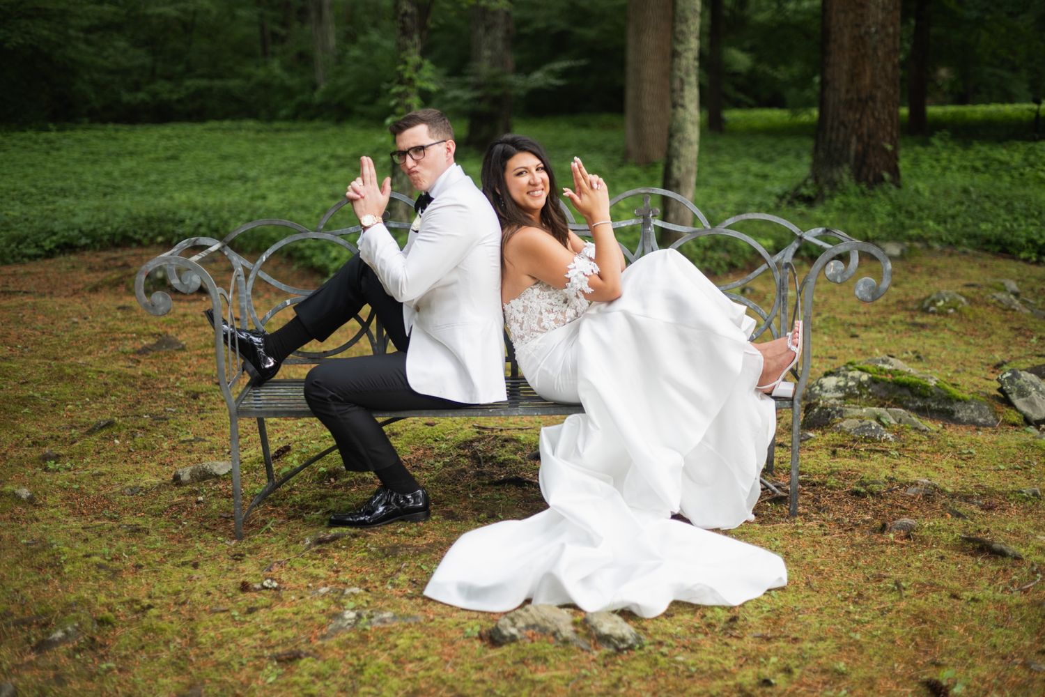 Candid wedding photography showing couple posing playfully on natural grounds.