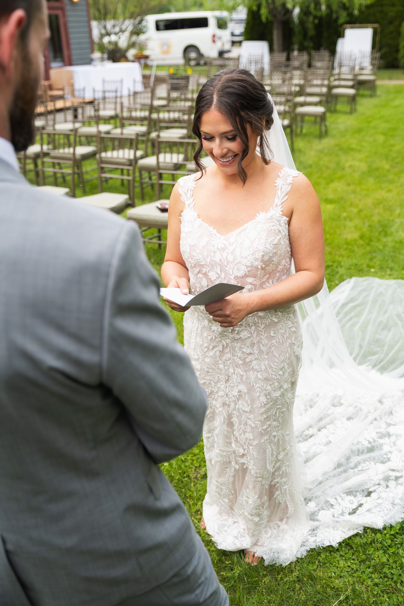 Wedding photographer captures an elegant white bridal gown with lace details in an outdoor garden setting.