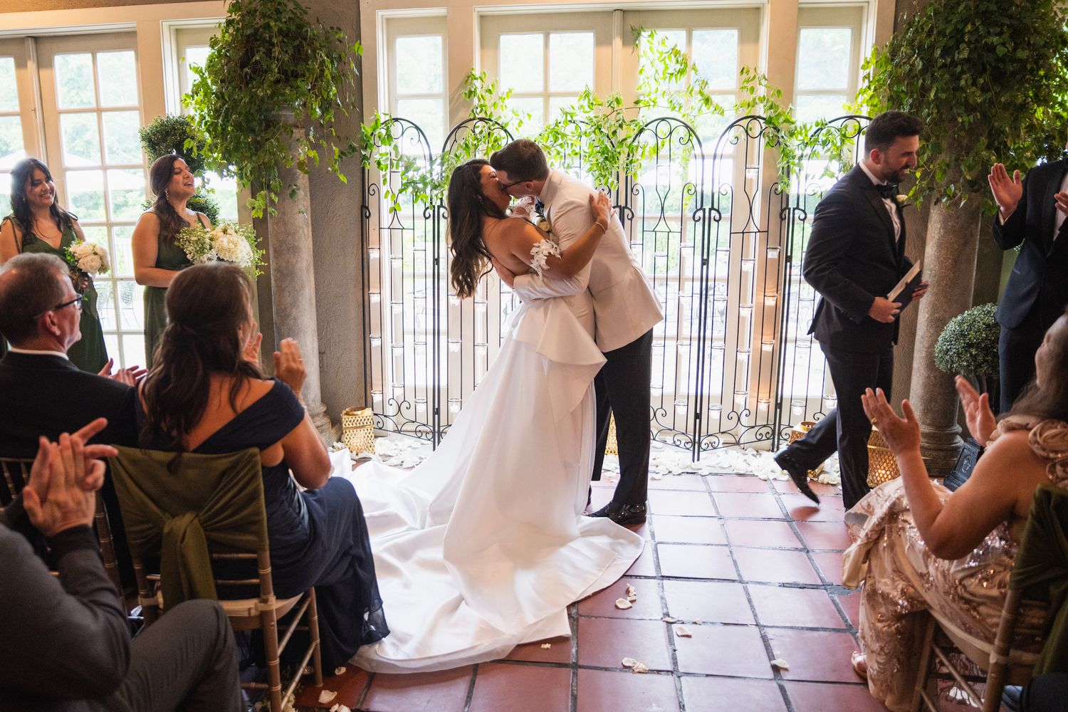 First dance moment in sunlit reception venue with guests watching from chairs.