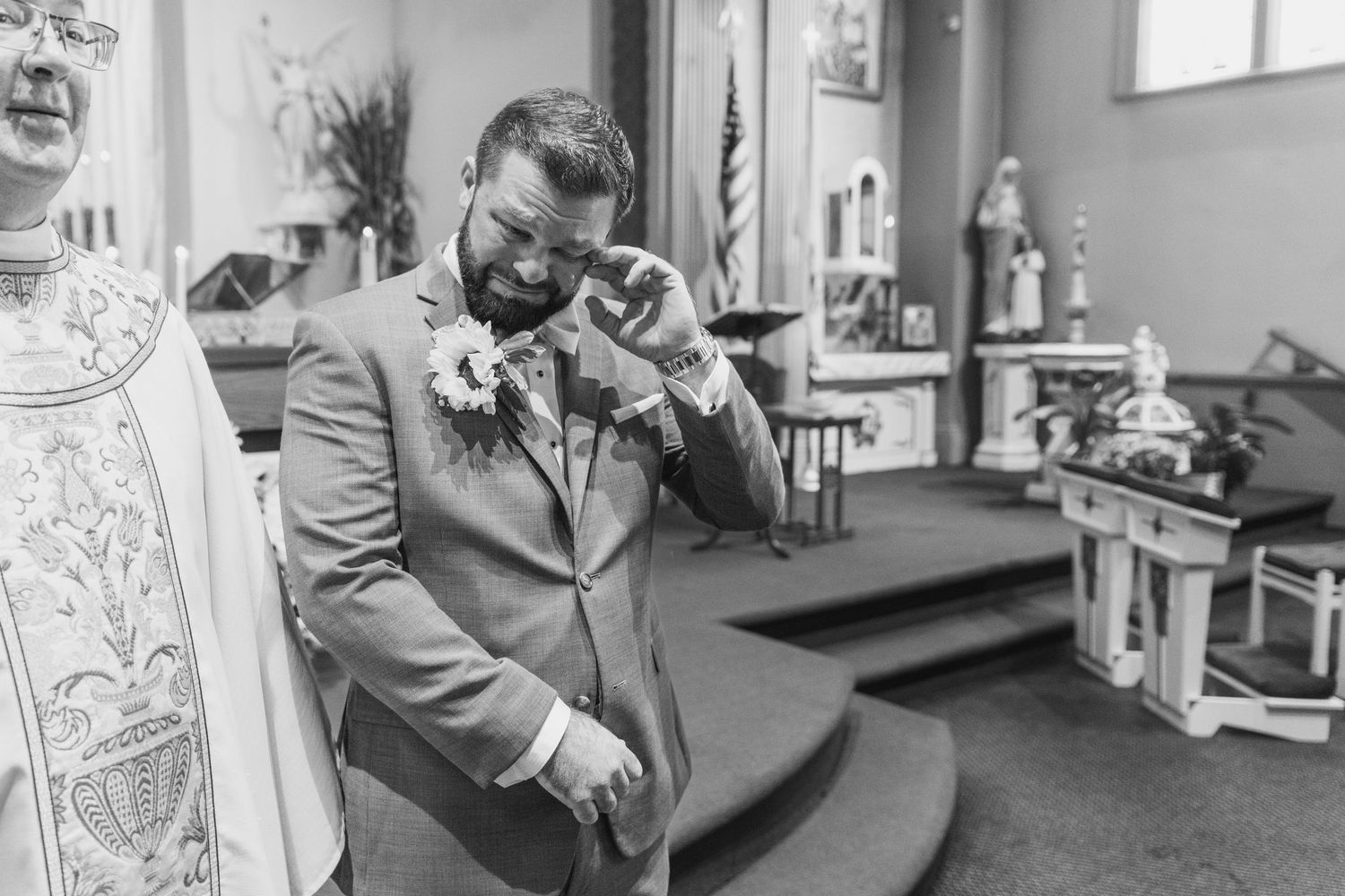 Black and white candid moments inside church before wedding ceremony.