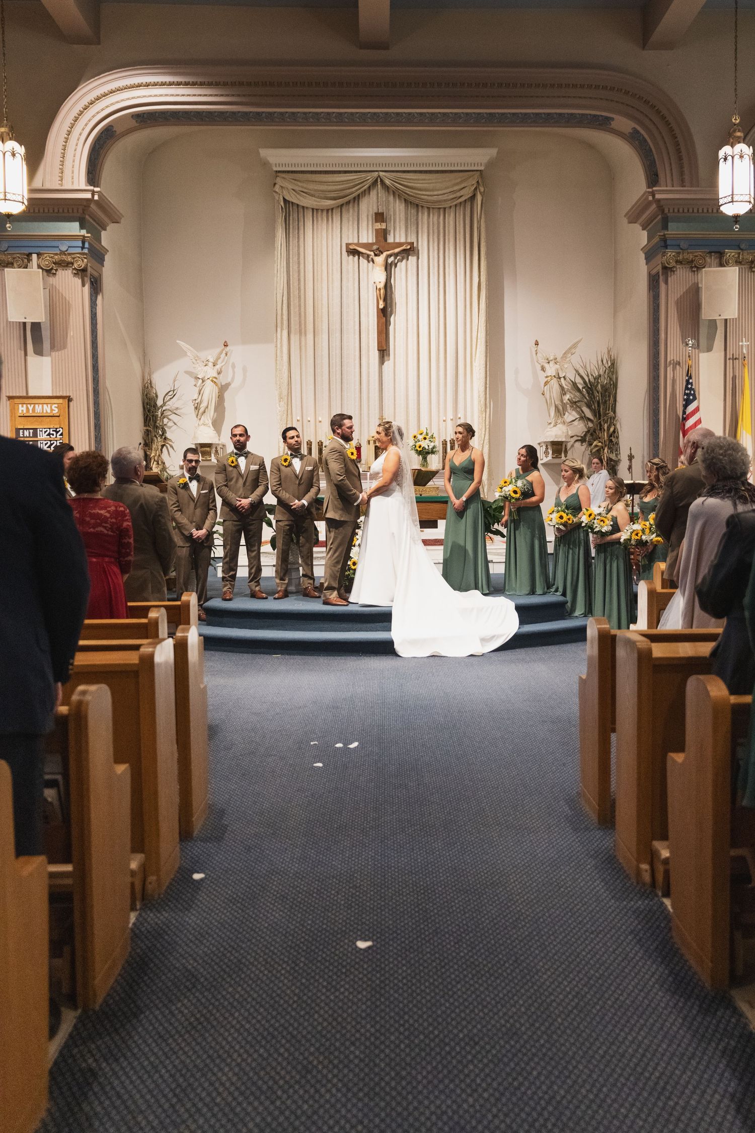 Wide angle view of traditional church wedding ceremony with pews and altar.