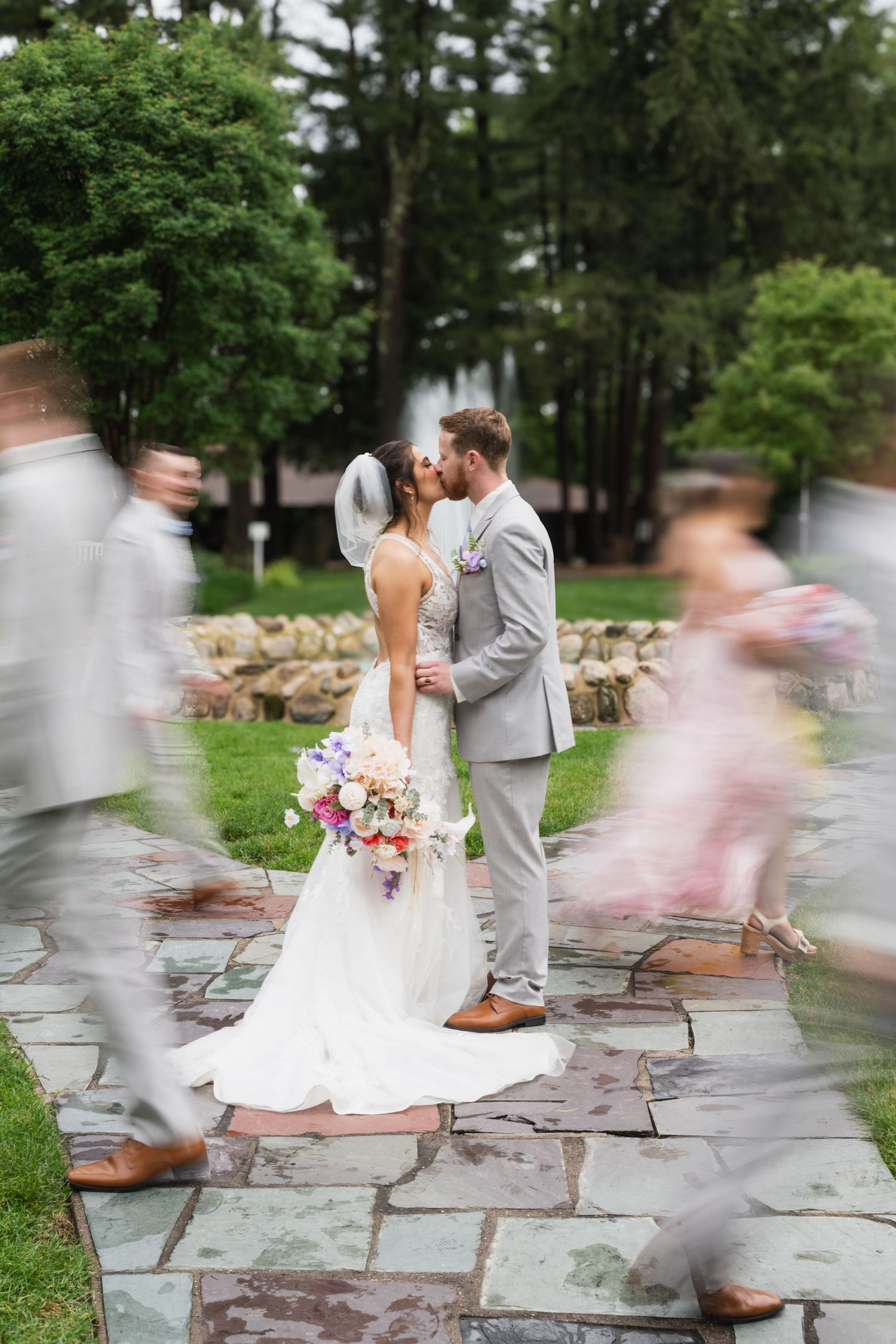 A wedding couple twirls on a stone patio in a dreamy motion blur photography sequence.