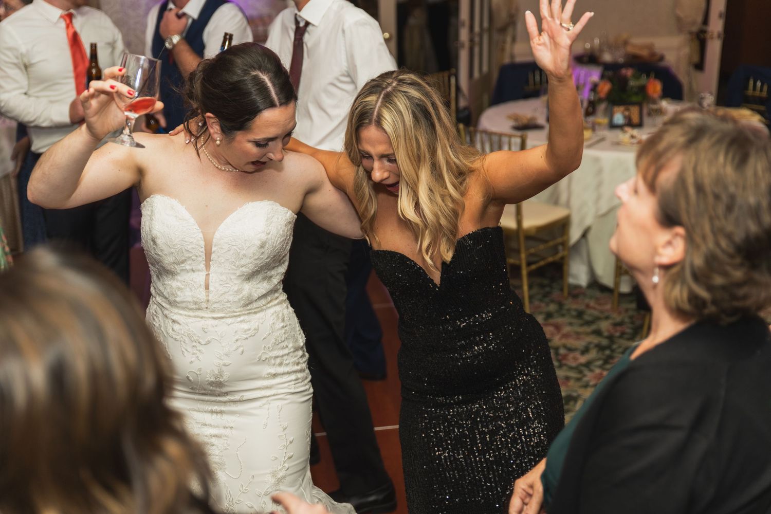 Wedding guests dance and celebrate together on a lively dance floor at a reception party.
