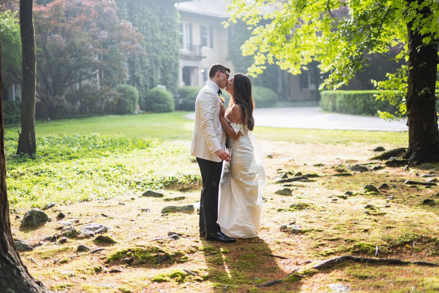 Couple embraces in a sunlit forest setting during their wedding photoshoot.