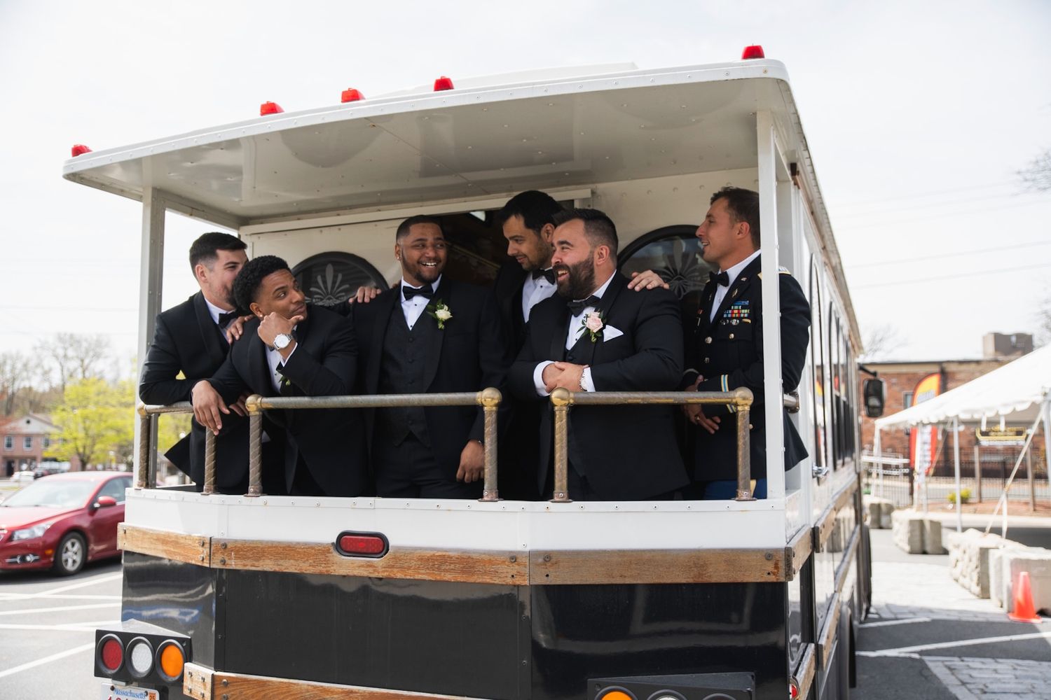 Wedding party rides in a white trolley bus during celebration festivities.