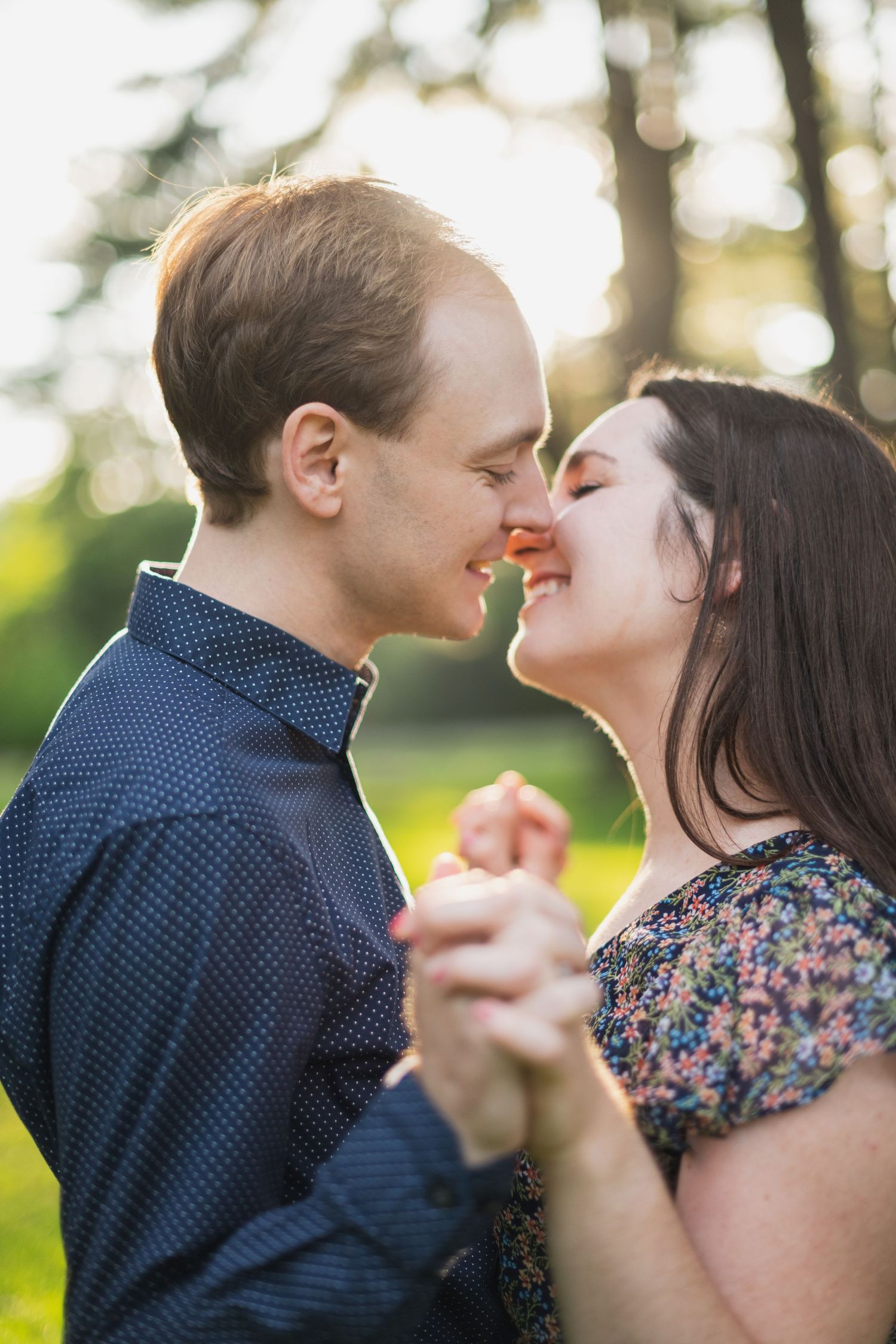 Couple sharing intimate dance moment in sunlit outdoor setting.
