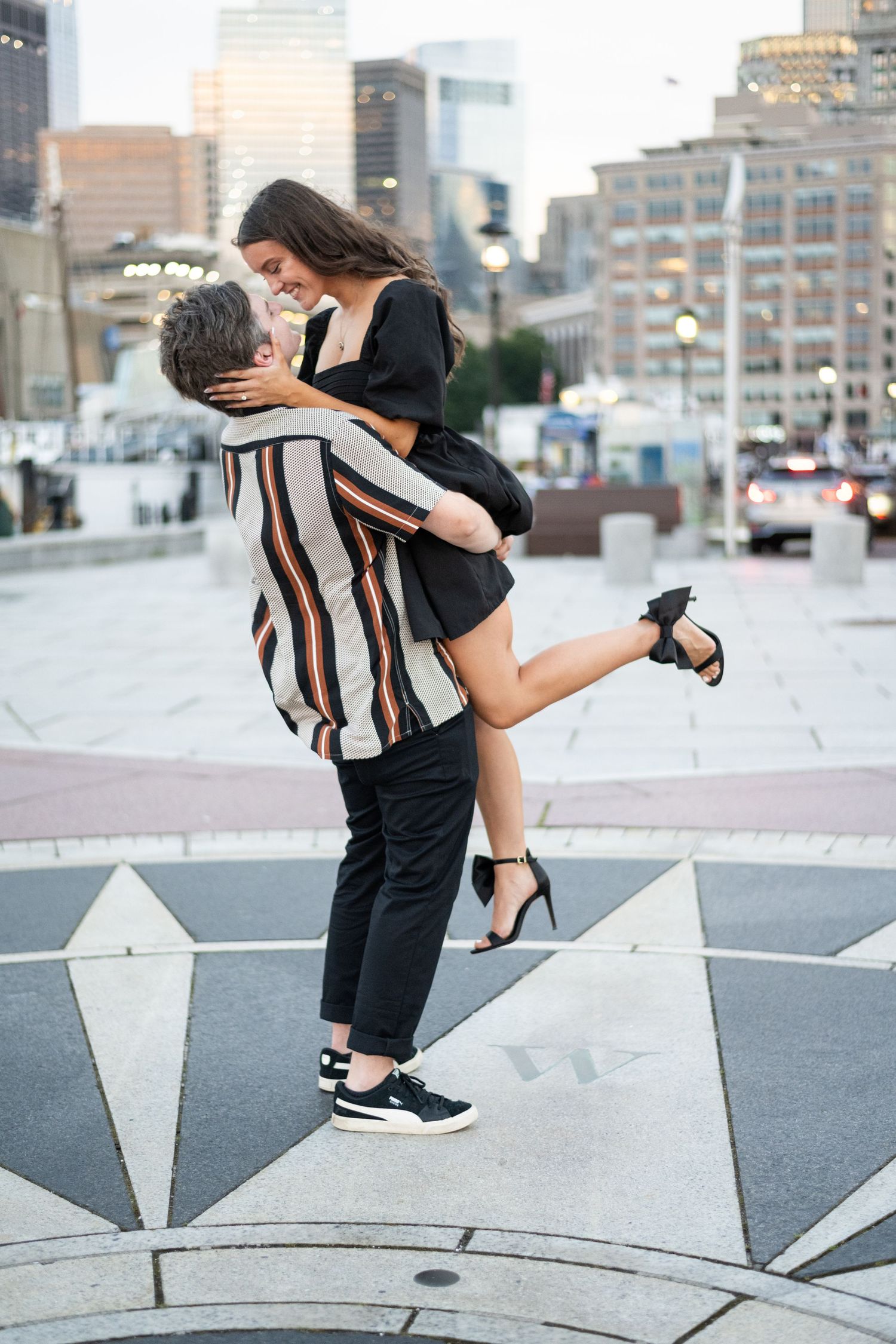 A couple poses for dynamic photos on a geometric patterned urban rooftop.
