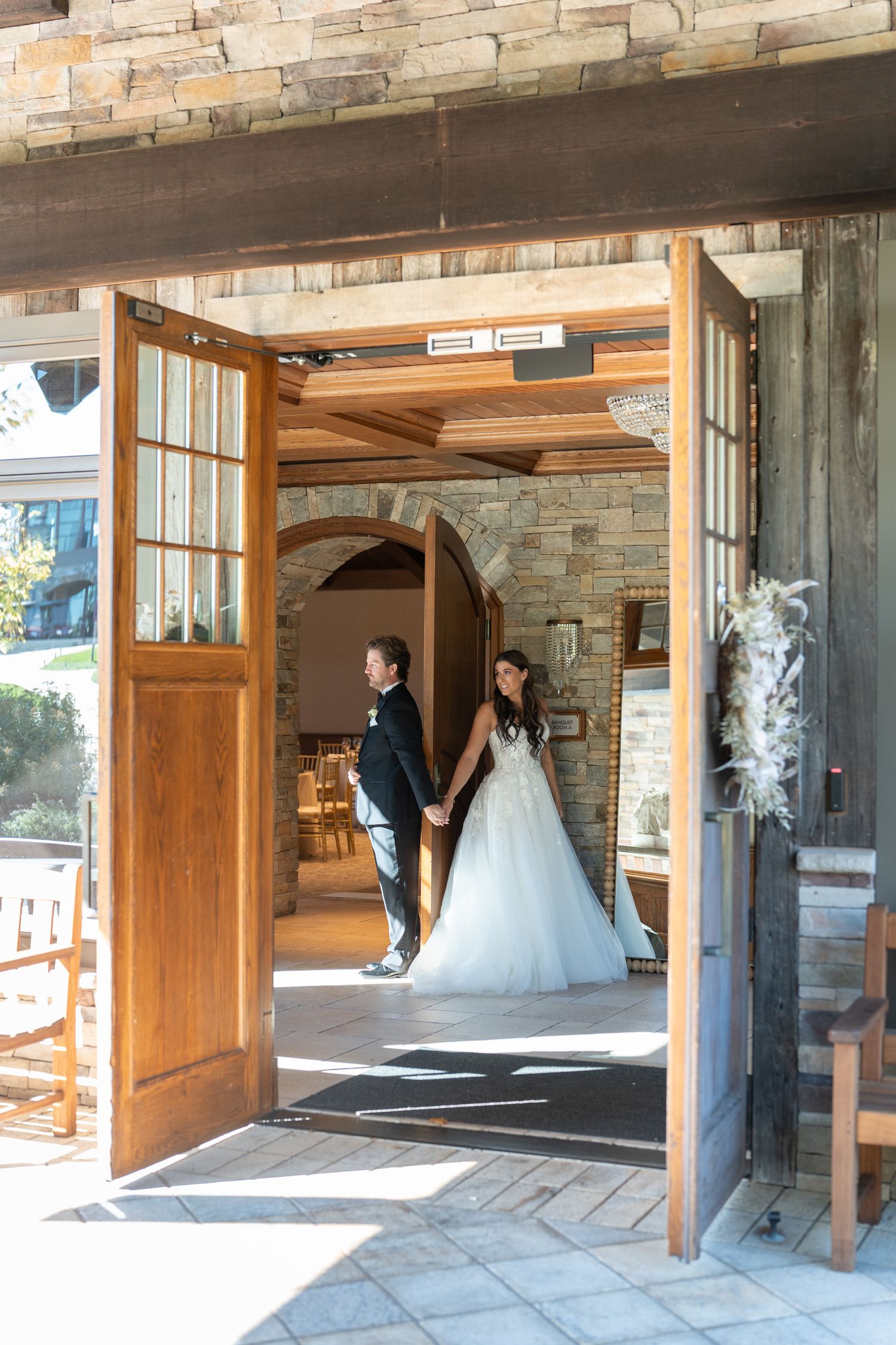 A sequence of four wedding photos showing a couple entering through a rustic wooden doorway with stone walls.