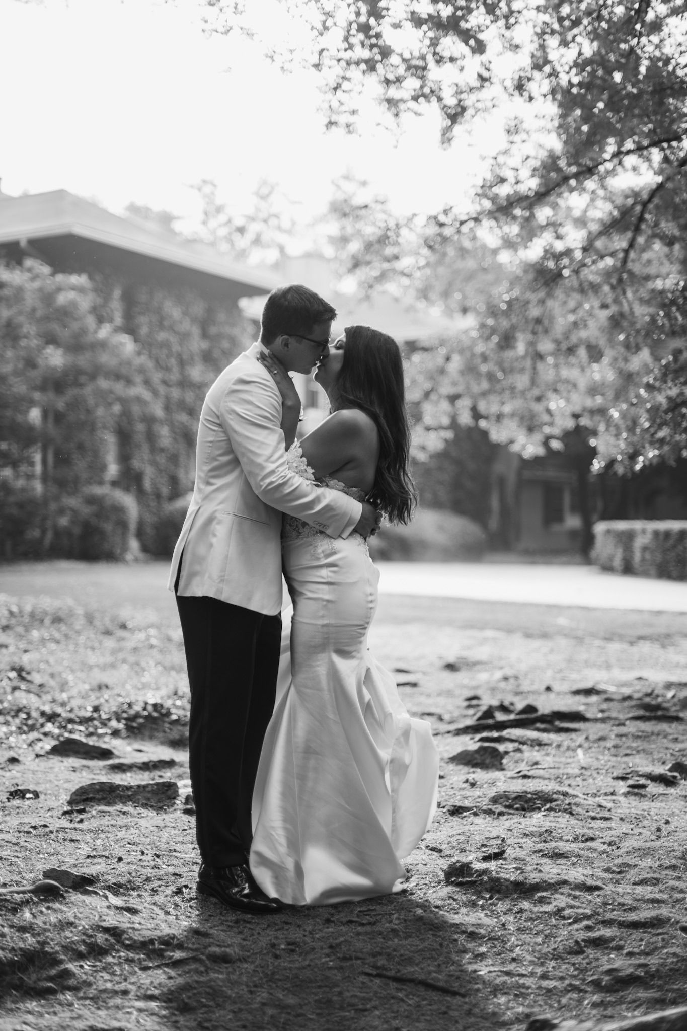 Romantic black and white portrait of couple embracing outdoors.