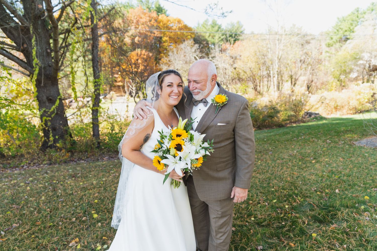 Joyful outdoor wedding portraits featuring sunflower bouquet and gray suit.