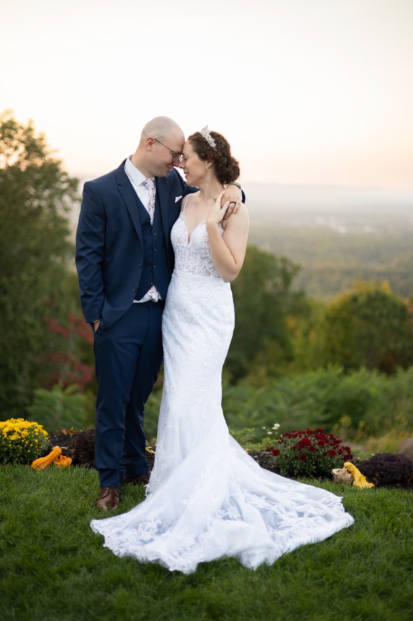 An intimate moment between newlyweds at sunset with fall foliage in the background.