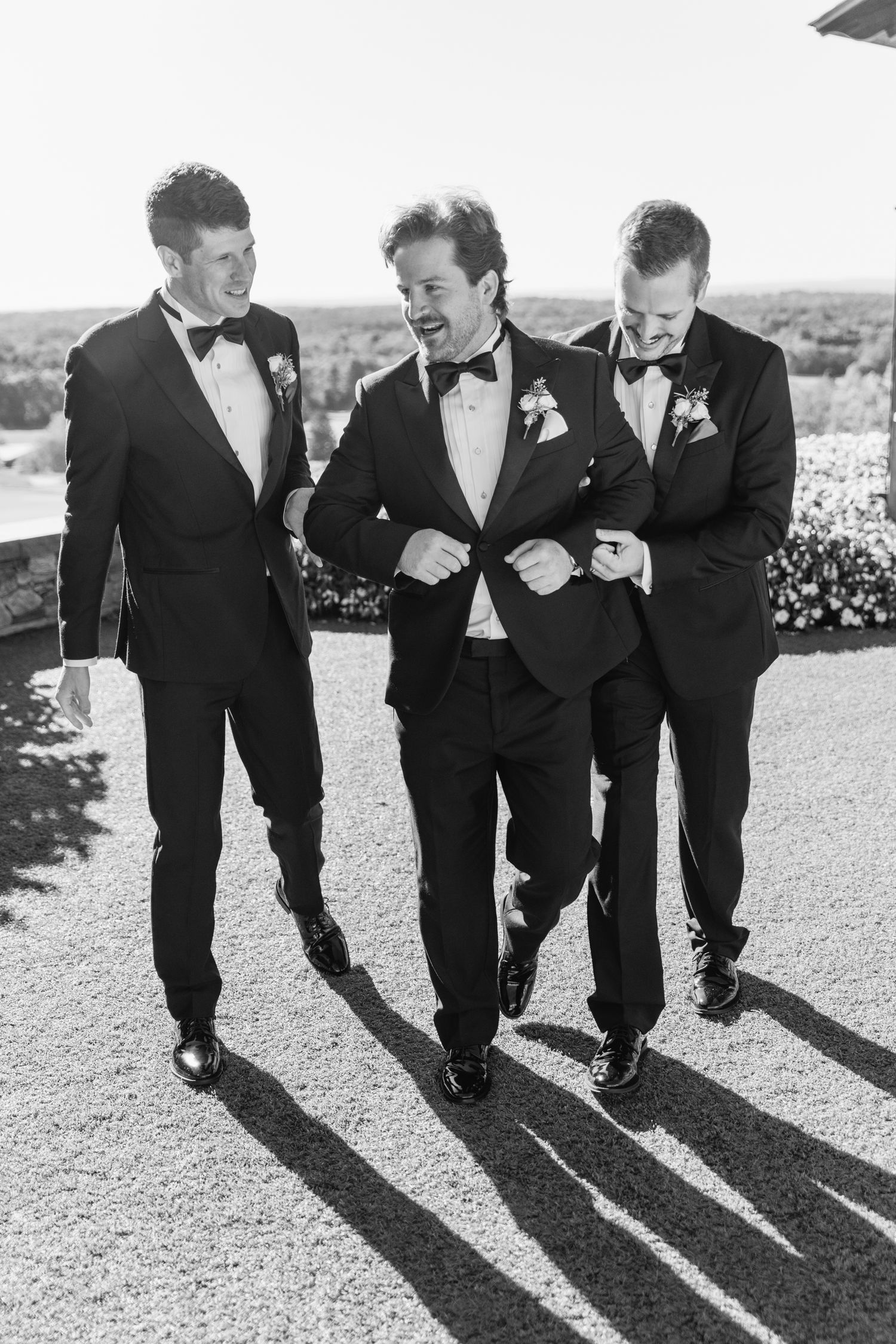 A sequence of black and white photos showing groomsmen kicking their legs in sync casting long shadows on the ground.