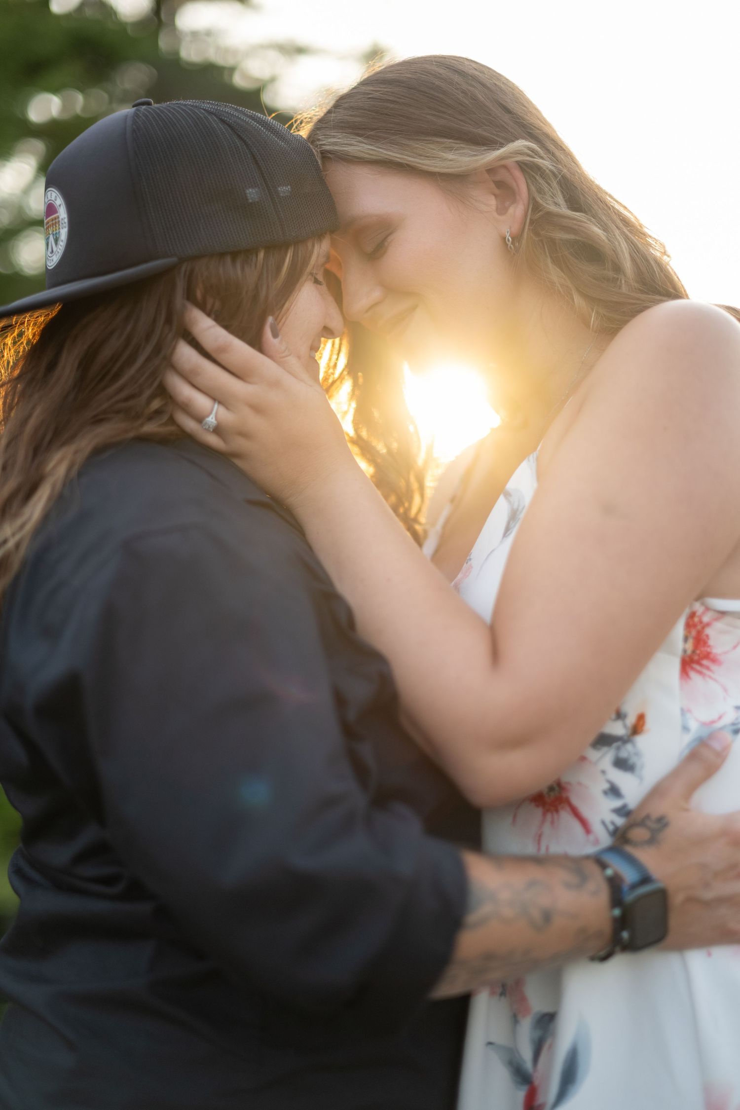 A sunset embrace between two people with golden light streaming through.