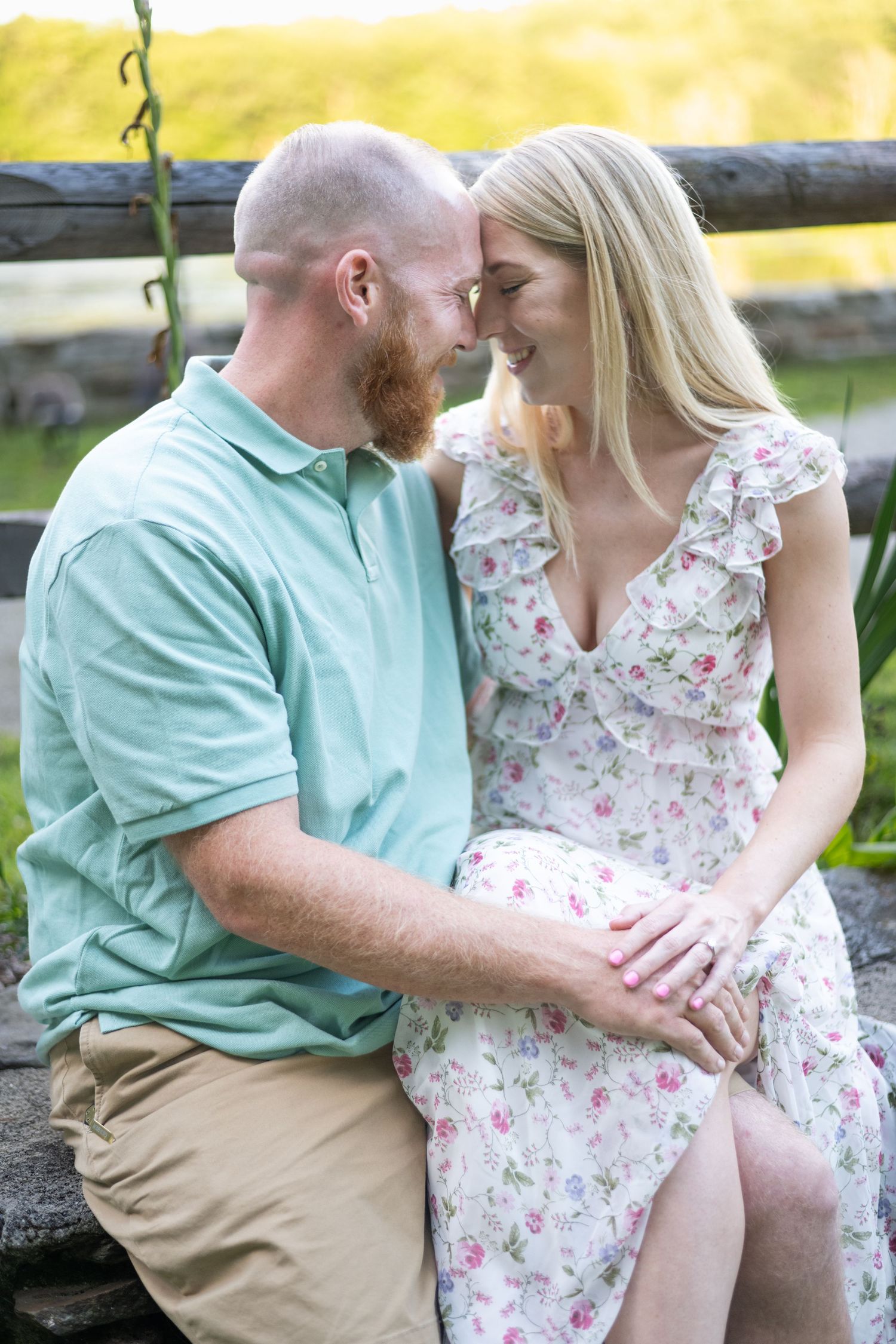 Couple shares romantic moment while sitting on rustic wooden bench outdoors.