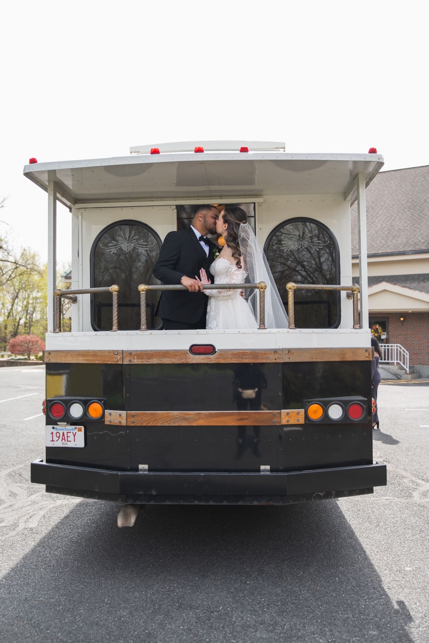 Newlyweds sharing a moment on back of vintage trolley bus.