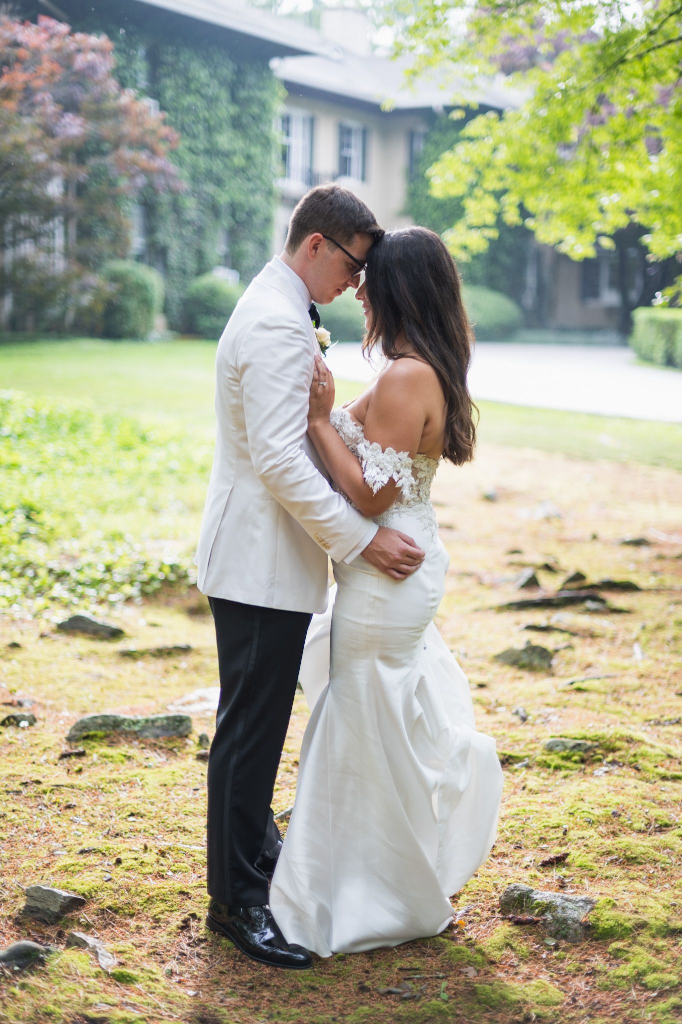 Romantic wedding couple sharing intimate moments together in an outdoor garden setting.