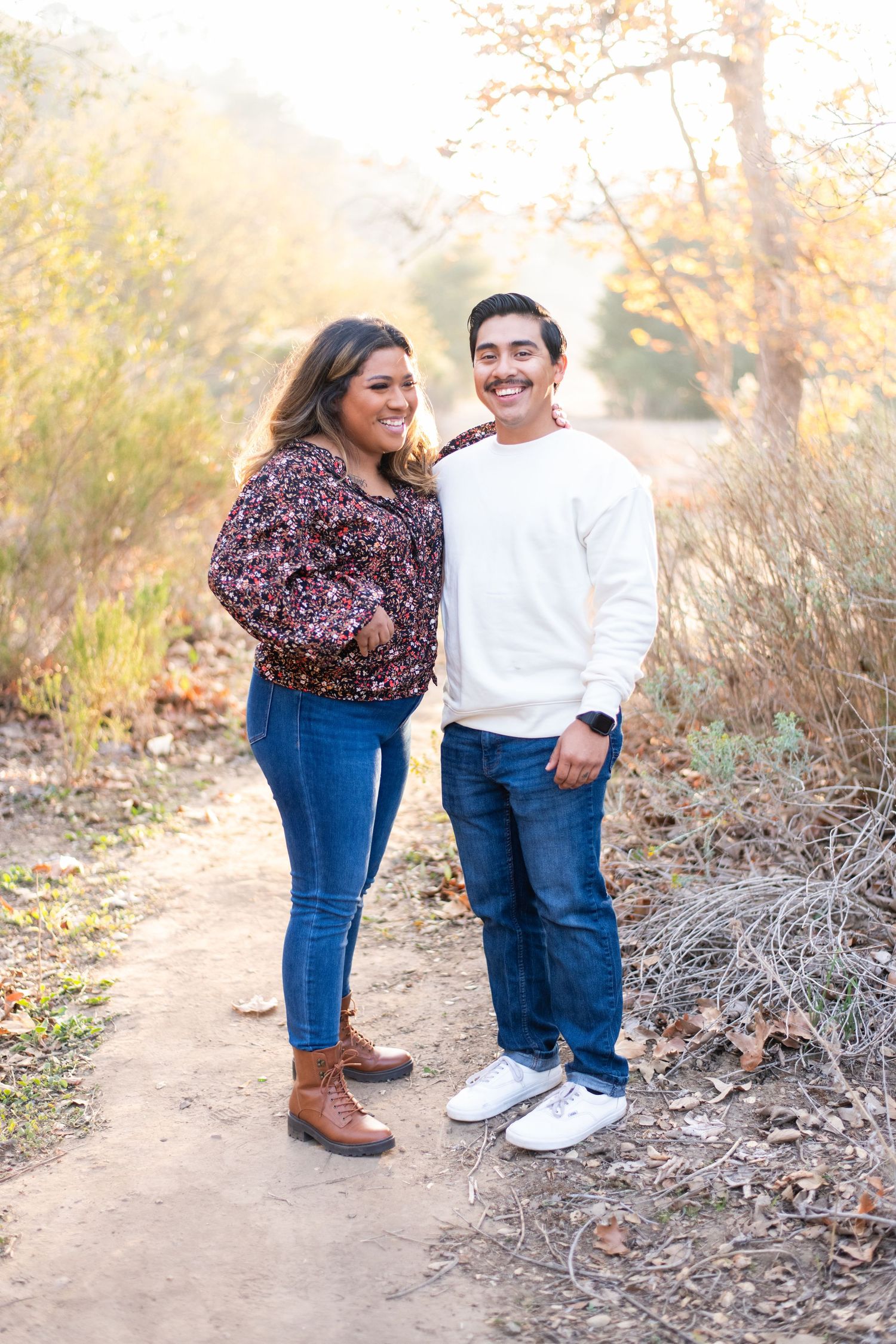 Couple sharing a joyful moment while standing on a nature trail.